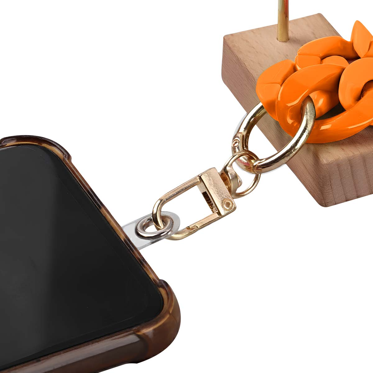 Una custodia per telefono con un cinturino collegato a un blocco di legno con una catena arancione. Il telefono è nero e la custodia marrone.