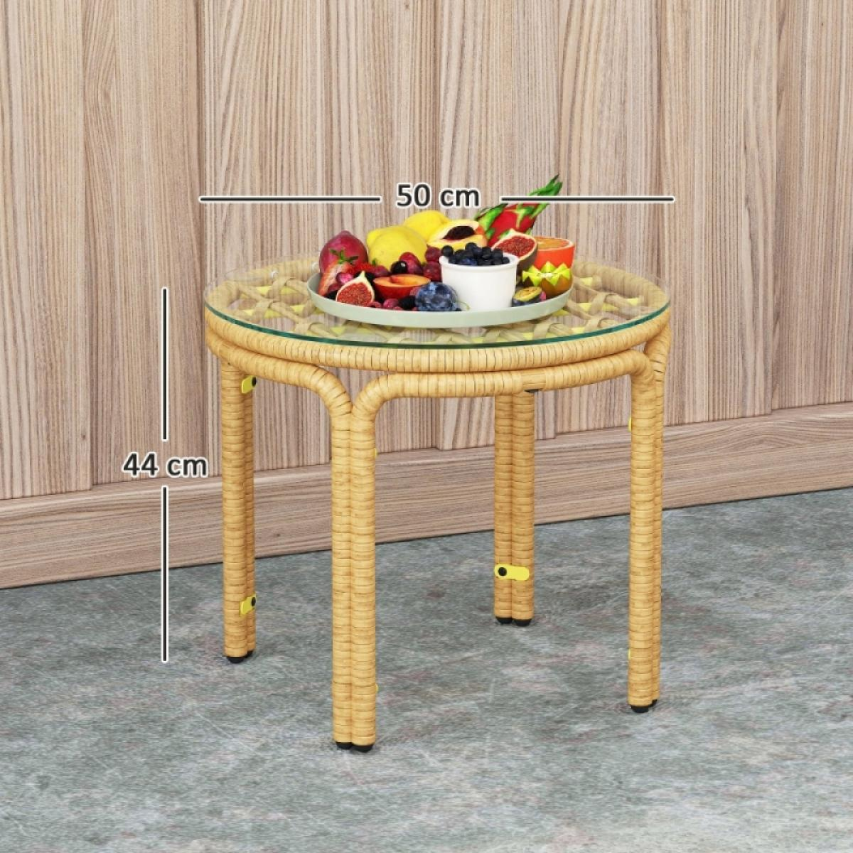 Ein runder Tisch mit Früchten, 44 cm hoch, 50 cm breit. Der Tisch hat eine Glasplatte und Korbstuhlbeine, steht auf grauem Boden.