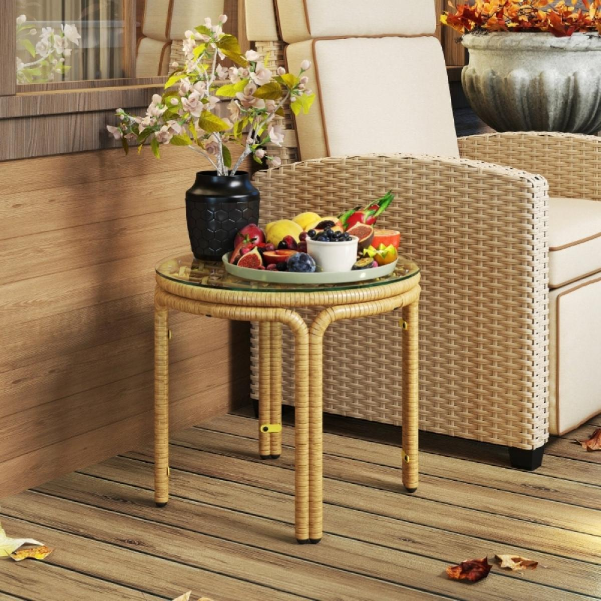 Ein Tisch mit Früchten und Blumen. Ein Korbstuhl und ein Topf mit Blumen sind im Hintergrund. Holzboden mit Blättern.