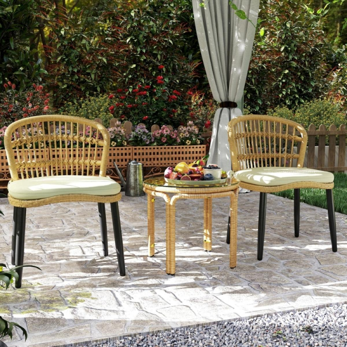Zwei Korbstühle und ein Tisch auf einer Terrasse. Früchte liegen auf dem Tisch. Grüne Pflanzen, Blumen und ein Vorhang sind im Hintergrund.