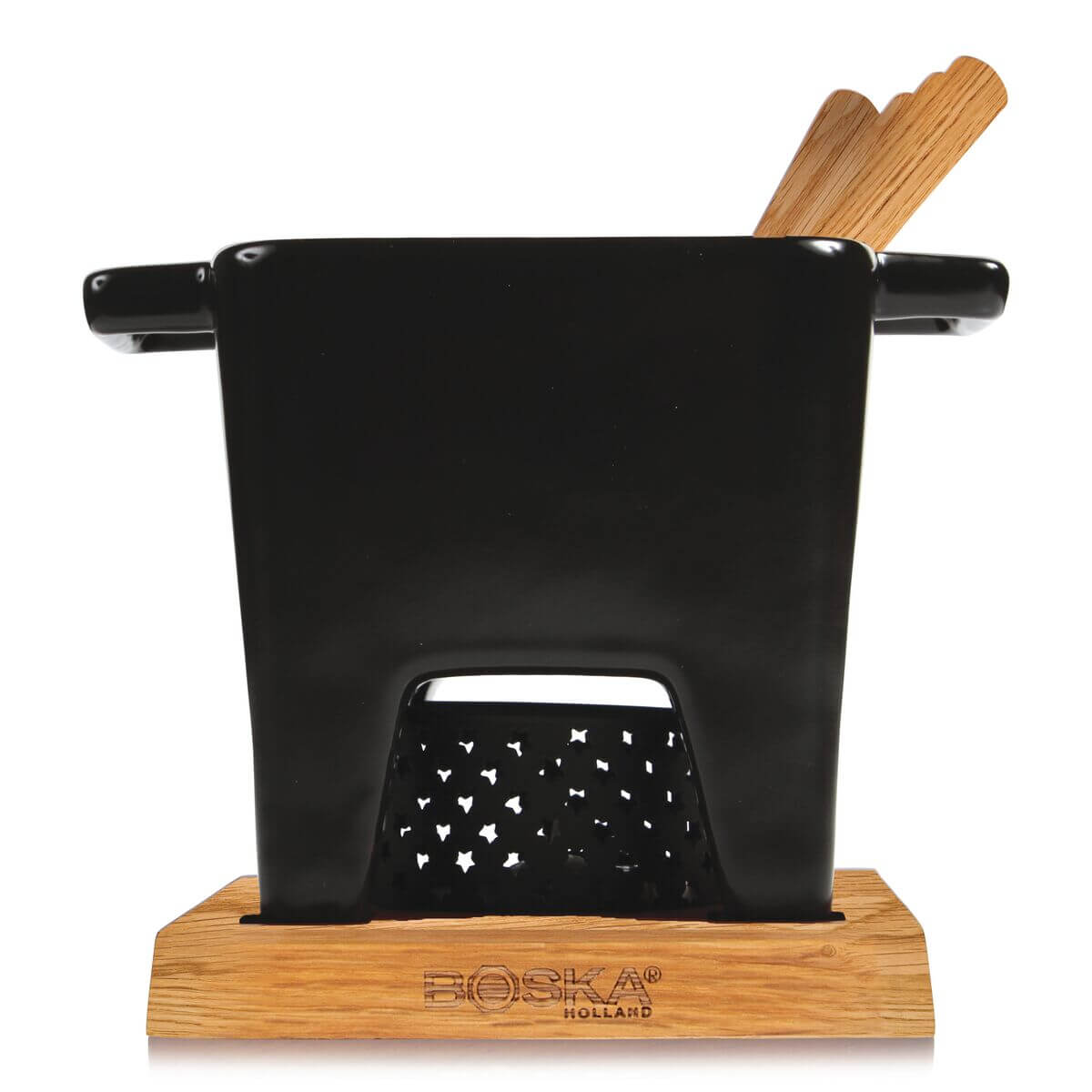 A black Boska Holland fondue pot with wooden handles, set on a wooden base. The front has star-shaped cutouts.