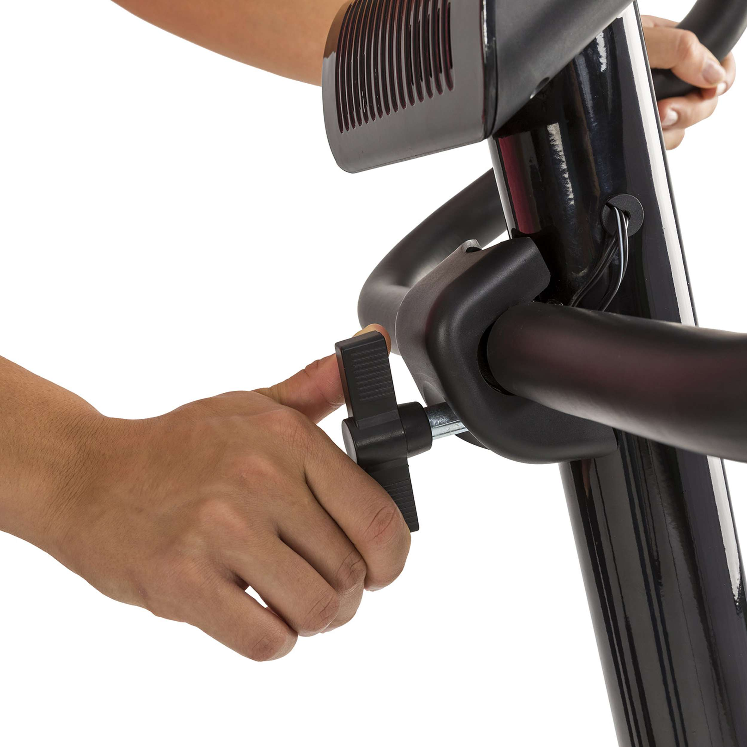 De hand van een persoon stelt een zwarte knop af op een hometrainer. De fiets heeft een zwart frame.