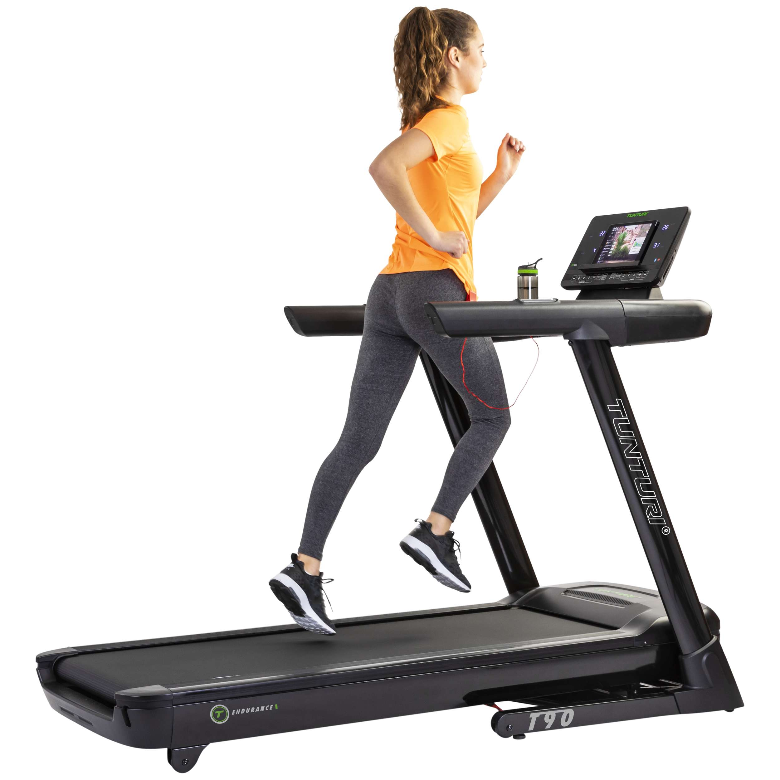 Een vrouw rent op een Tunturi T90 loopband. Ze draagt een oranje shirt en grijze leggings. Er staat een waterfles op de machine.