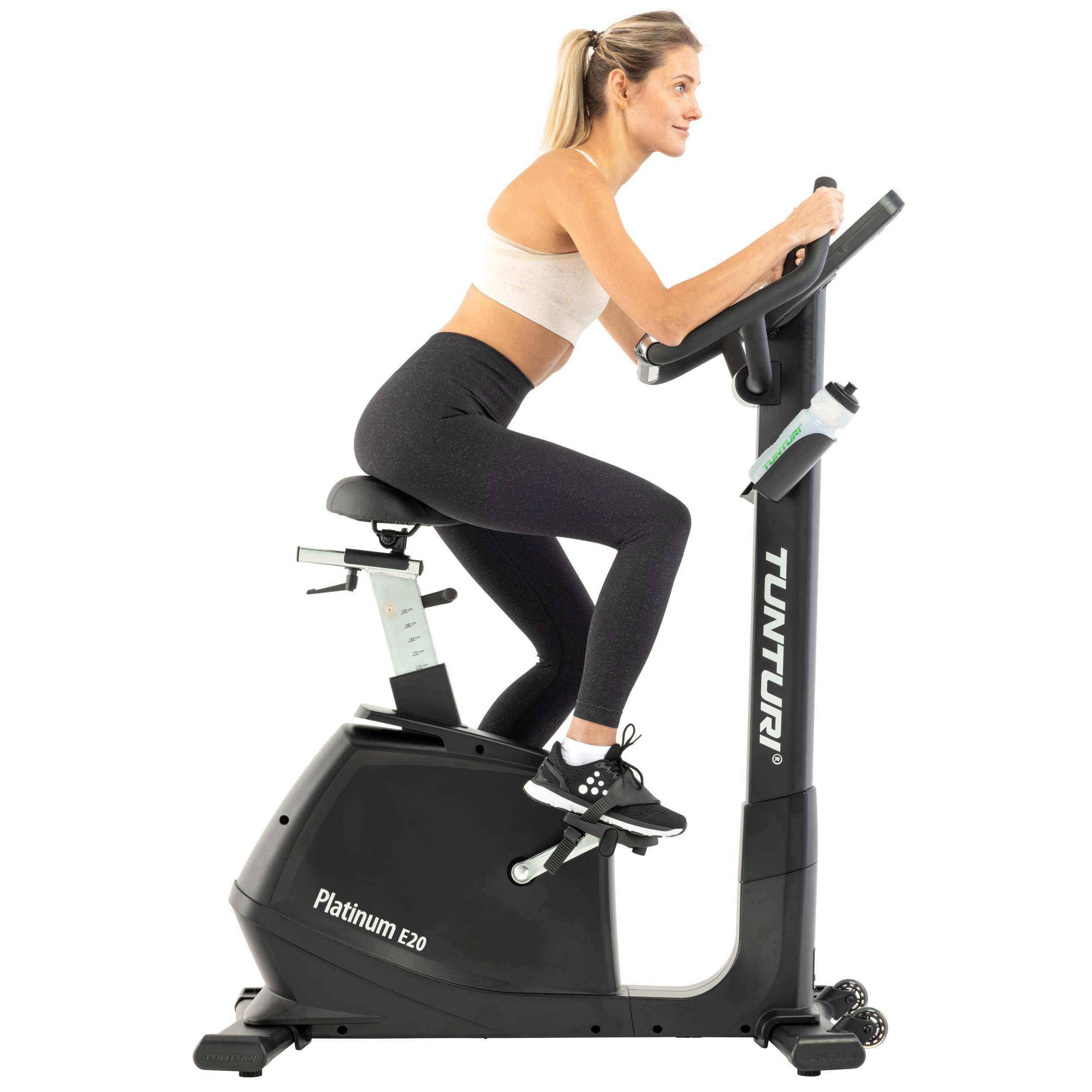 Vrouw op een Tunturi Platinum E20 hometrainer. Ze draagt sportkleding. Fiets is zwart met een waterfles.