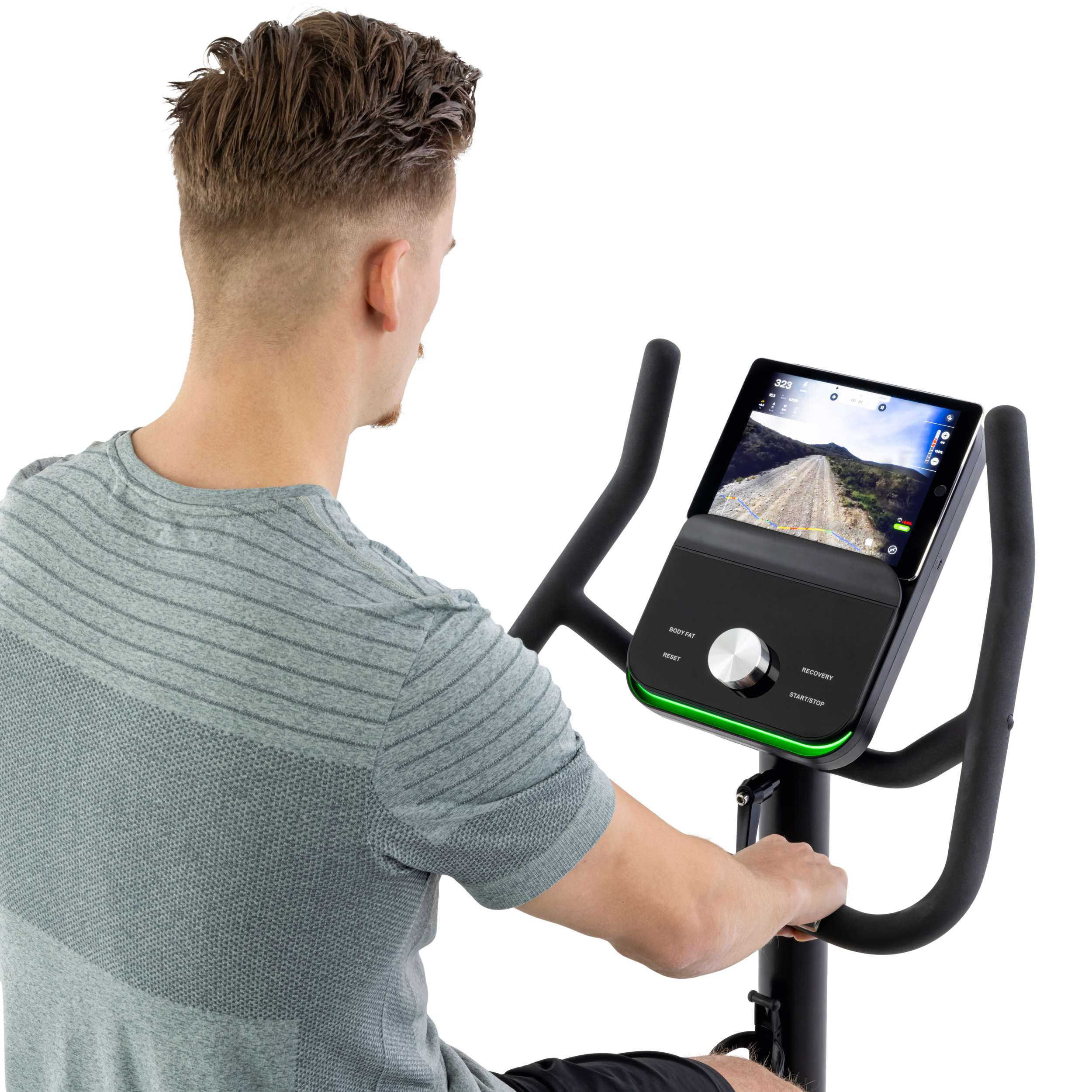 Man op hometrainer. Hij kijkt naar het scherm met een wegweergave. Zwarte handvatten en console met knoppen.