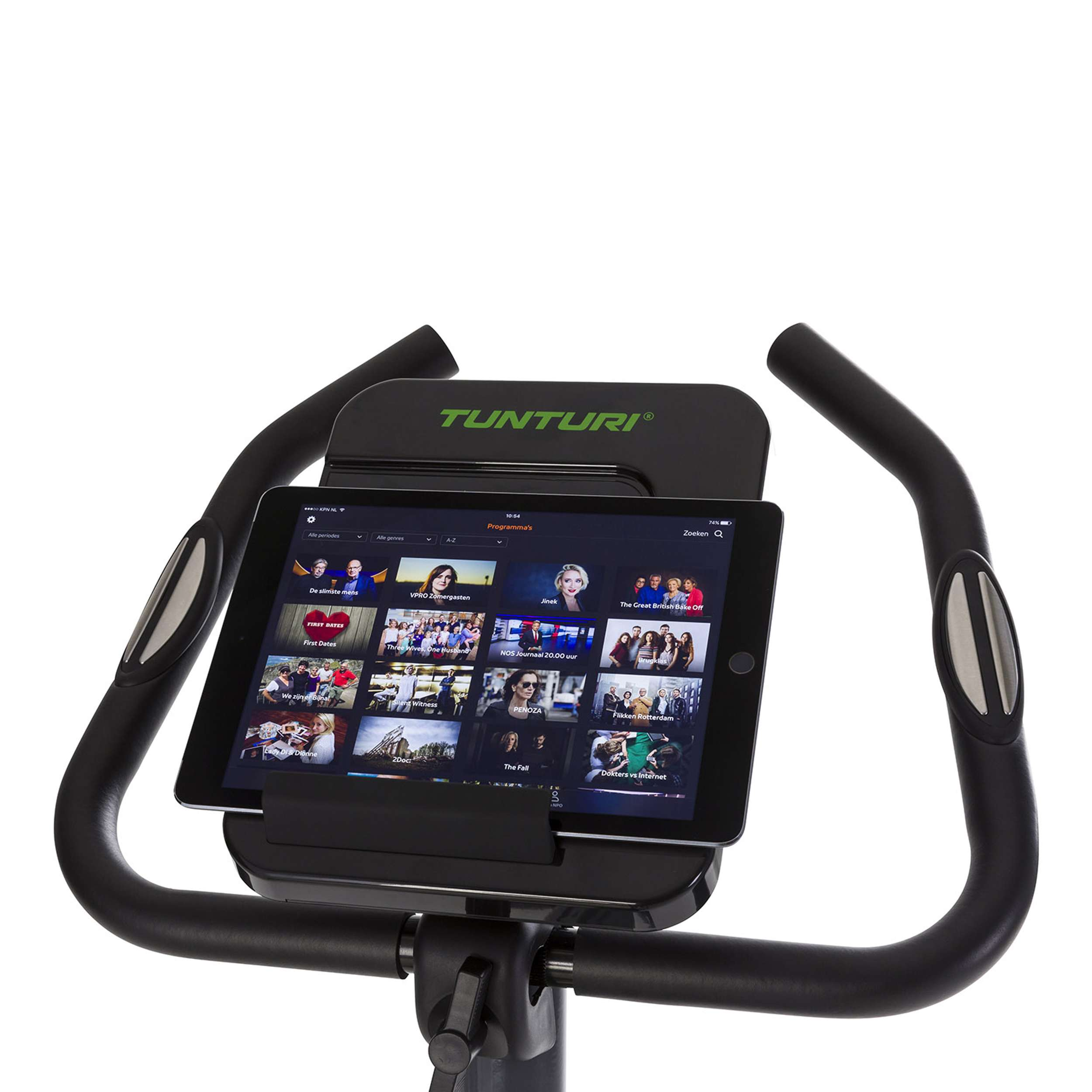 Hometrainer met tablet die streaming content weergeeft. Zwart frame, zilveren accenten, witte achtergrond.