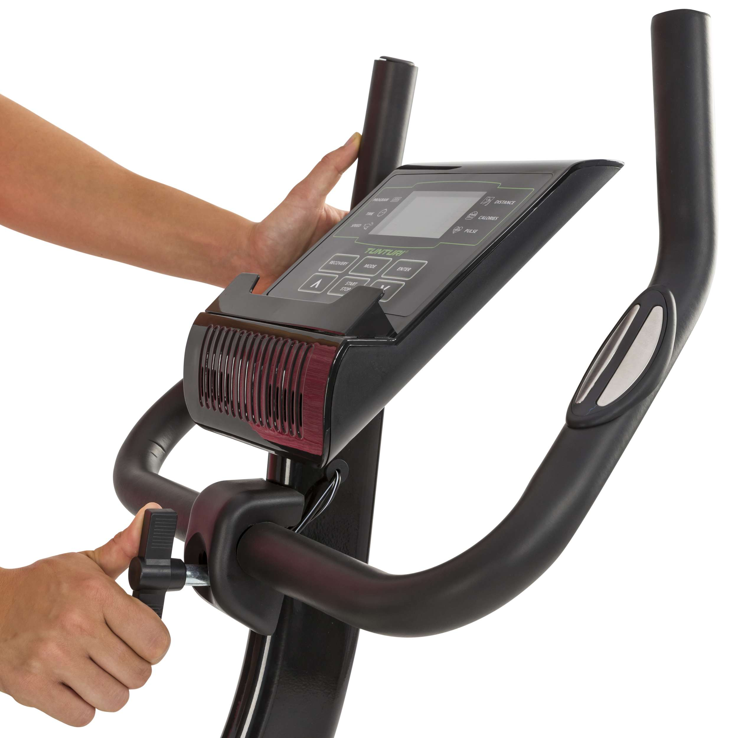 Een persoon past een zwarte hometrainer aan. De fiets heeft een scherm en handvatten. Handen zijn zichtbaar.