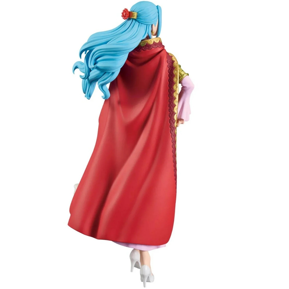 Una statuetta di una donna con capelli blu, mantello rosso e tacchi bianchi. La figura è vista da dietro, in piedi su uno sfondo bianco.