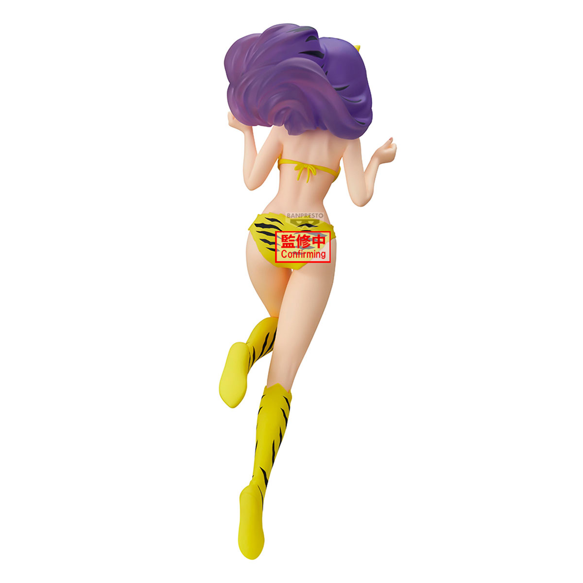 Figur einer Frau mit lila Haaren, gelbem Bikini und Stiefeln. Der Hintergrund ist weiß. Auf dem Rücken befindet sich ein roter Aufkleber.