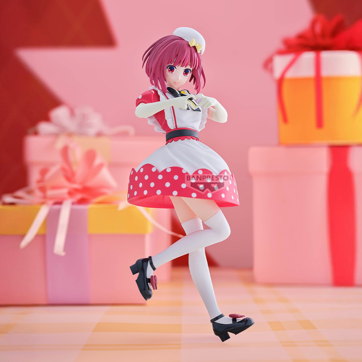 Figura de anime con traje de doncella, vestido rojo y blanco, zapatos negros y medias blancas. Cajas de regalo al fondo.