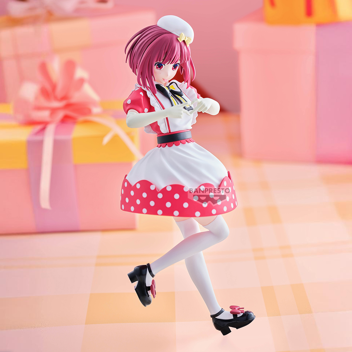Figura de anime, cabello rosa, atuendo de doncella con lunares rojos, guantes blancos, zapatos negros y un sombrero blanco. Fondo: cajas de regalo.