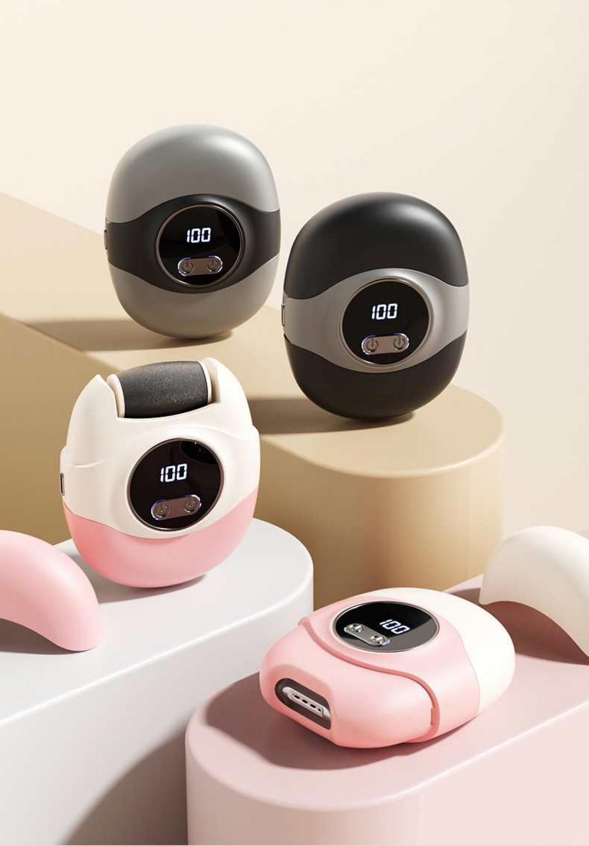 Vier Fußpflegegeräte in Rosa, Schwarz und Grau. Jedes zeigt '100' auf einem digitalen Display. Sie ruhen auf einer gestuften Oberfläche.