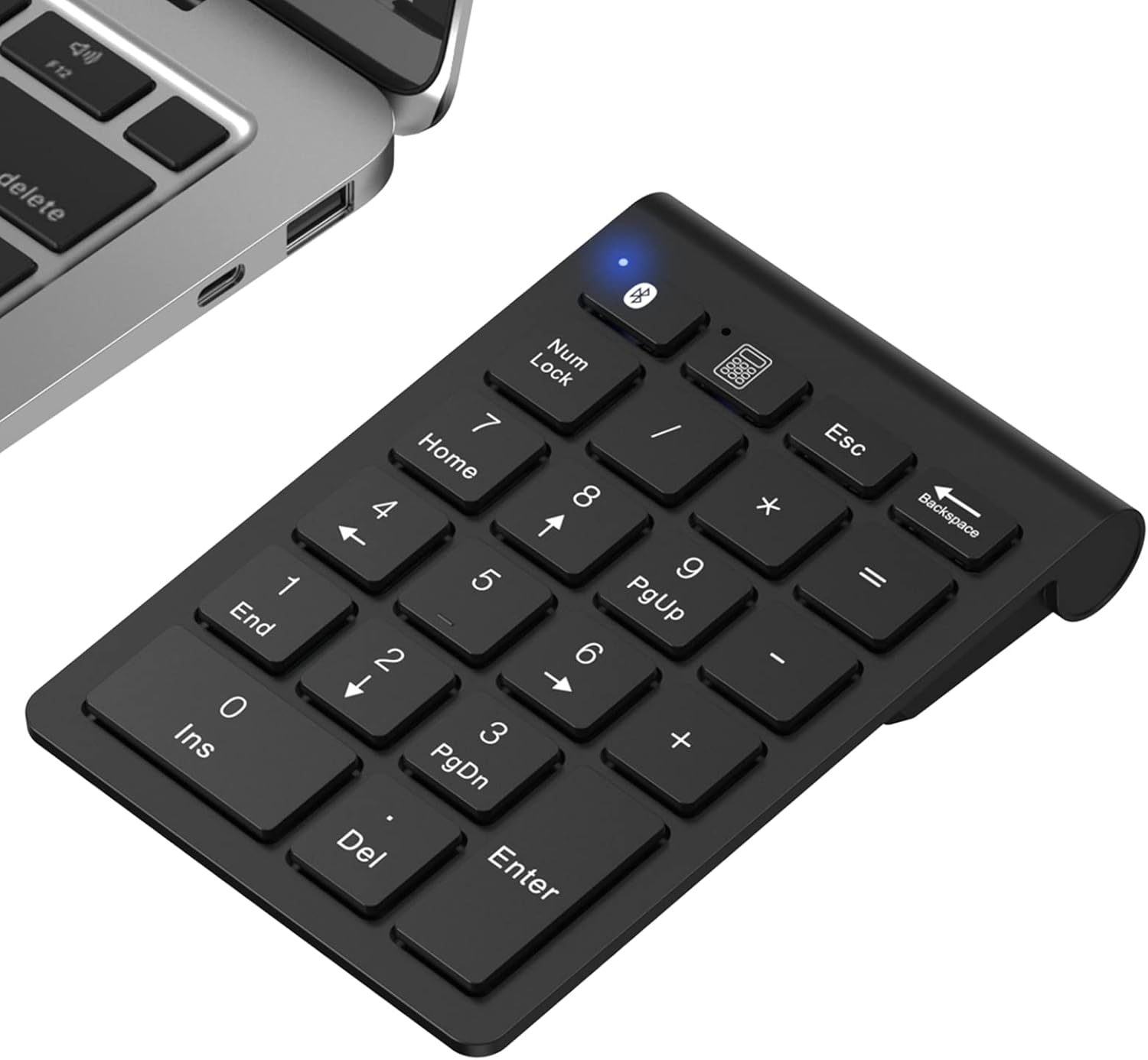 Schwarzes Nummernfeld mit weißen Tastenkennzeichnungen, in der Nähe eines Laptops platziert. Bluetooth-Symbol leuchtet. Tasten umfassen Zahlen, Symbole und Funktionen.