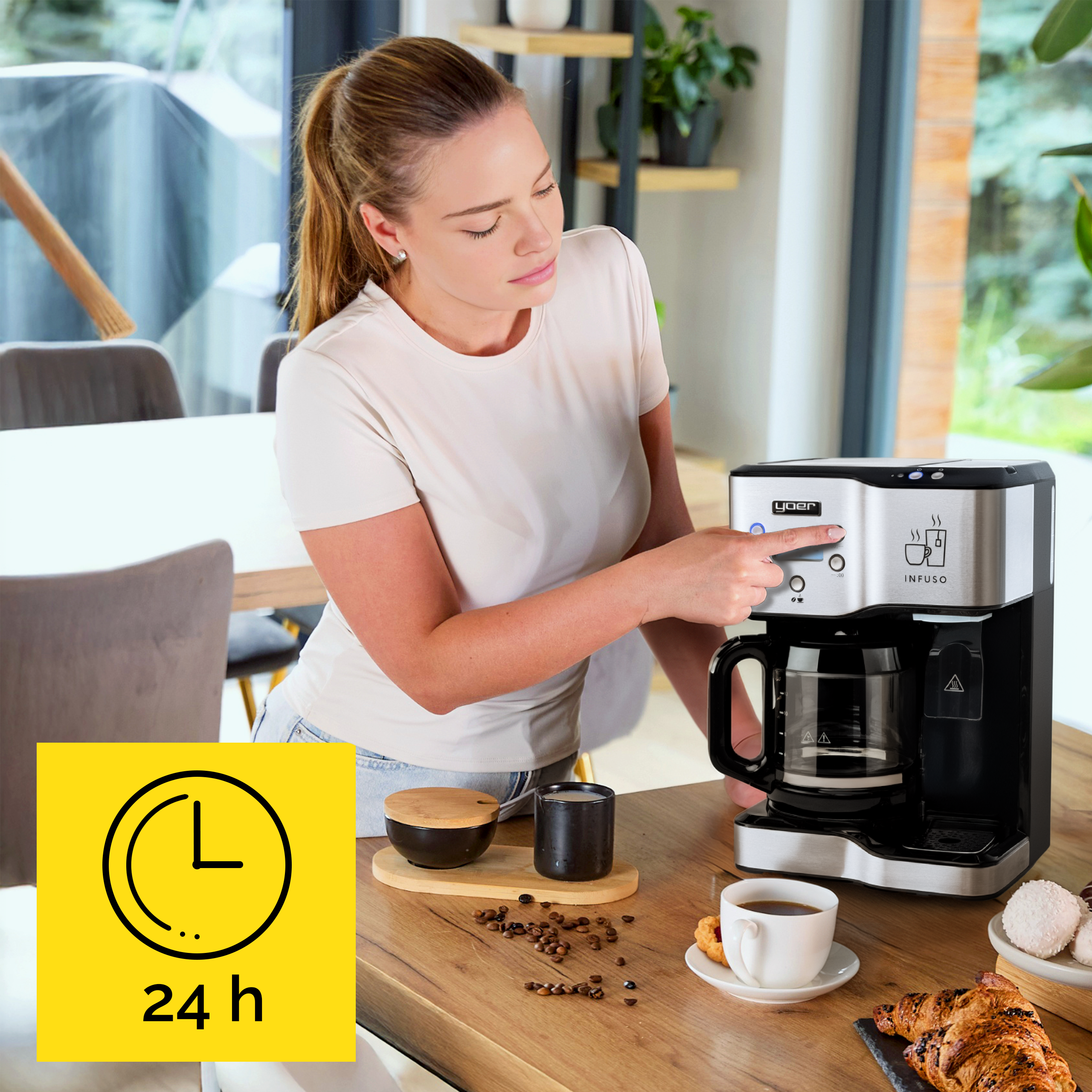 Kobieta używa ekspresu do kawy. Kawa, rogaliki i słodycze na stole. Zegar z 24 h w rogu.