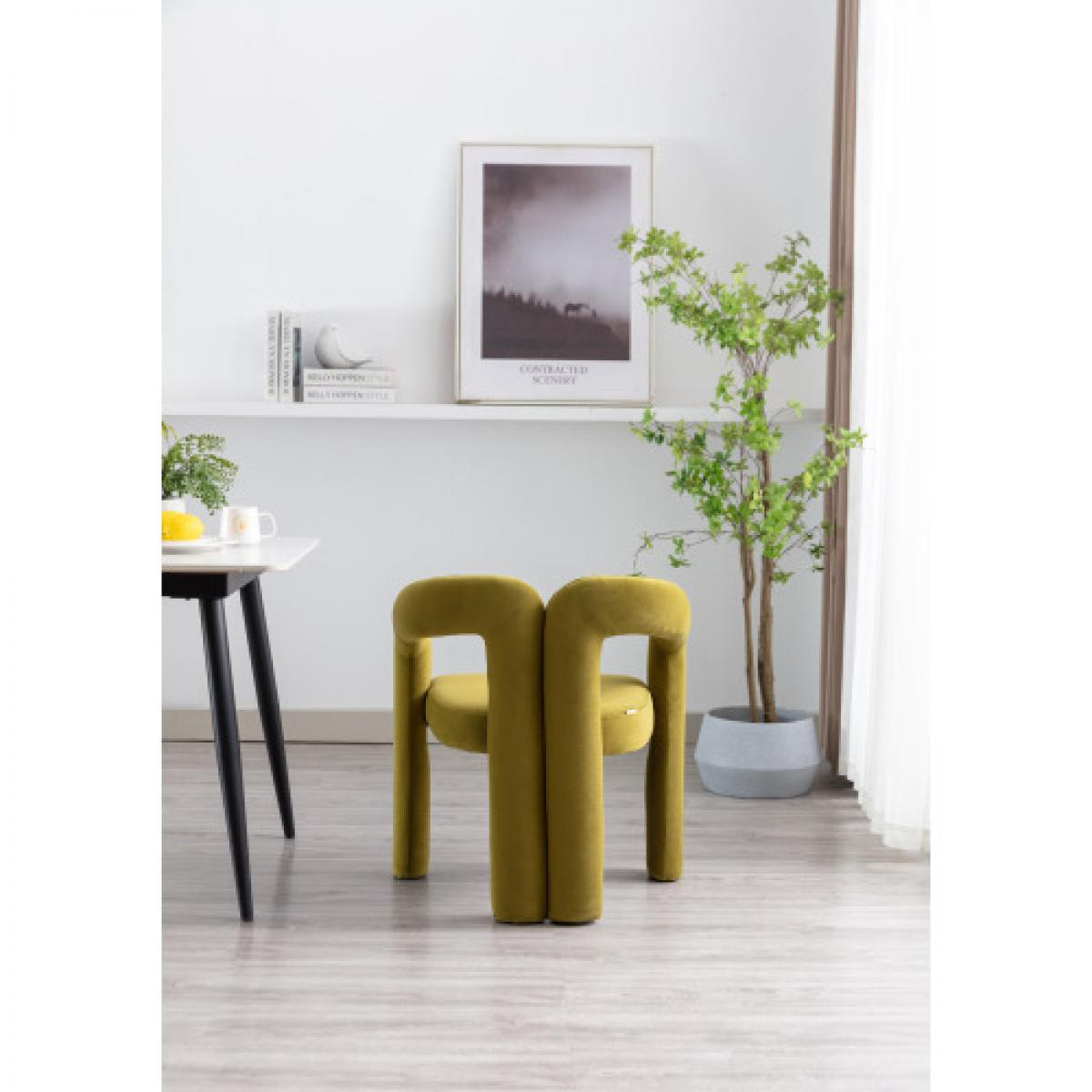 Ein olivgrüner Stuhl mit einzigartigem Design steht in einem Raum. Ein Tisch mit Zitrone und Tasse ist davor, rechts eine Pflanze.