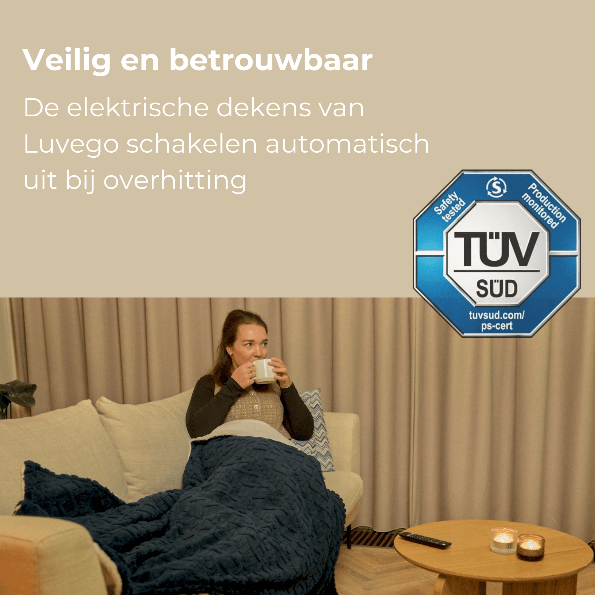 Eine Frau sitzt auf einem Sofa, in eine blaue Decke gehüllt, und trinkt aus einem Becher. Auf einem Tisch stehen Kerzen.