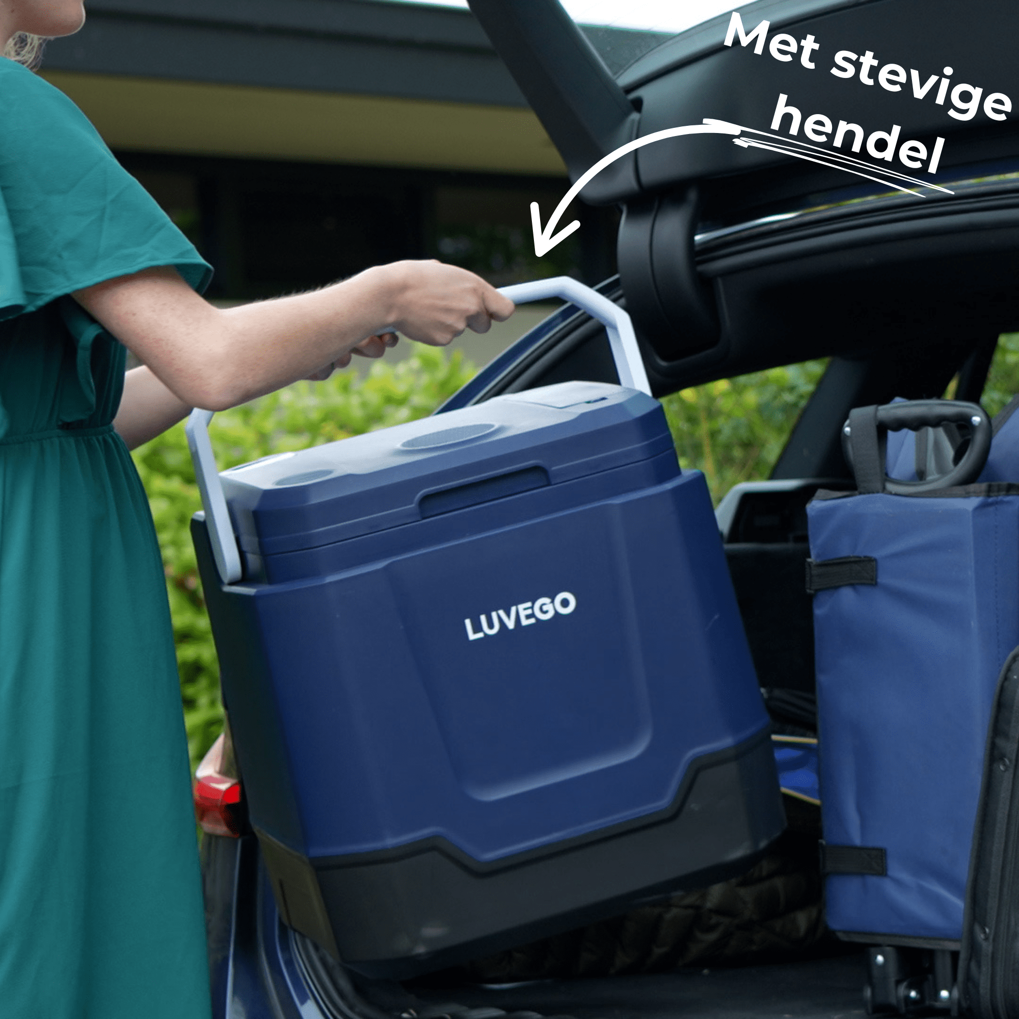 Eine Frau verlädt einen marineblauen Kühler mit weißem Griff in einen Kofferraum. Der Kühler hat den Markennamen Luvago.