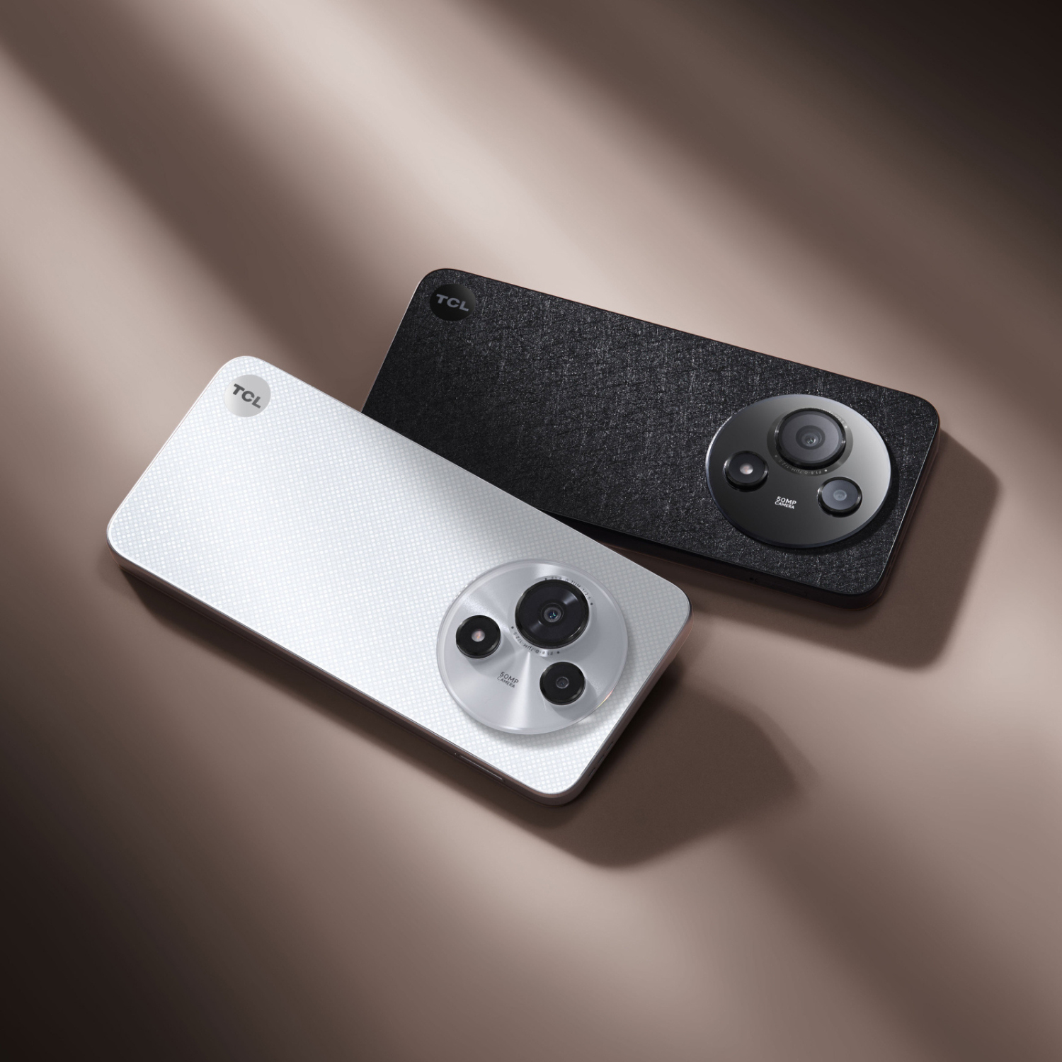 Dwa smartfony TCL. Jeden biały, jeden czarny. Oba mają okrągły design aparatu. Tło jest brązowe z lekkim cieniem.