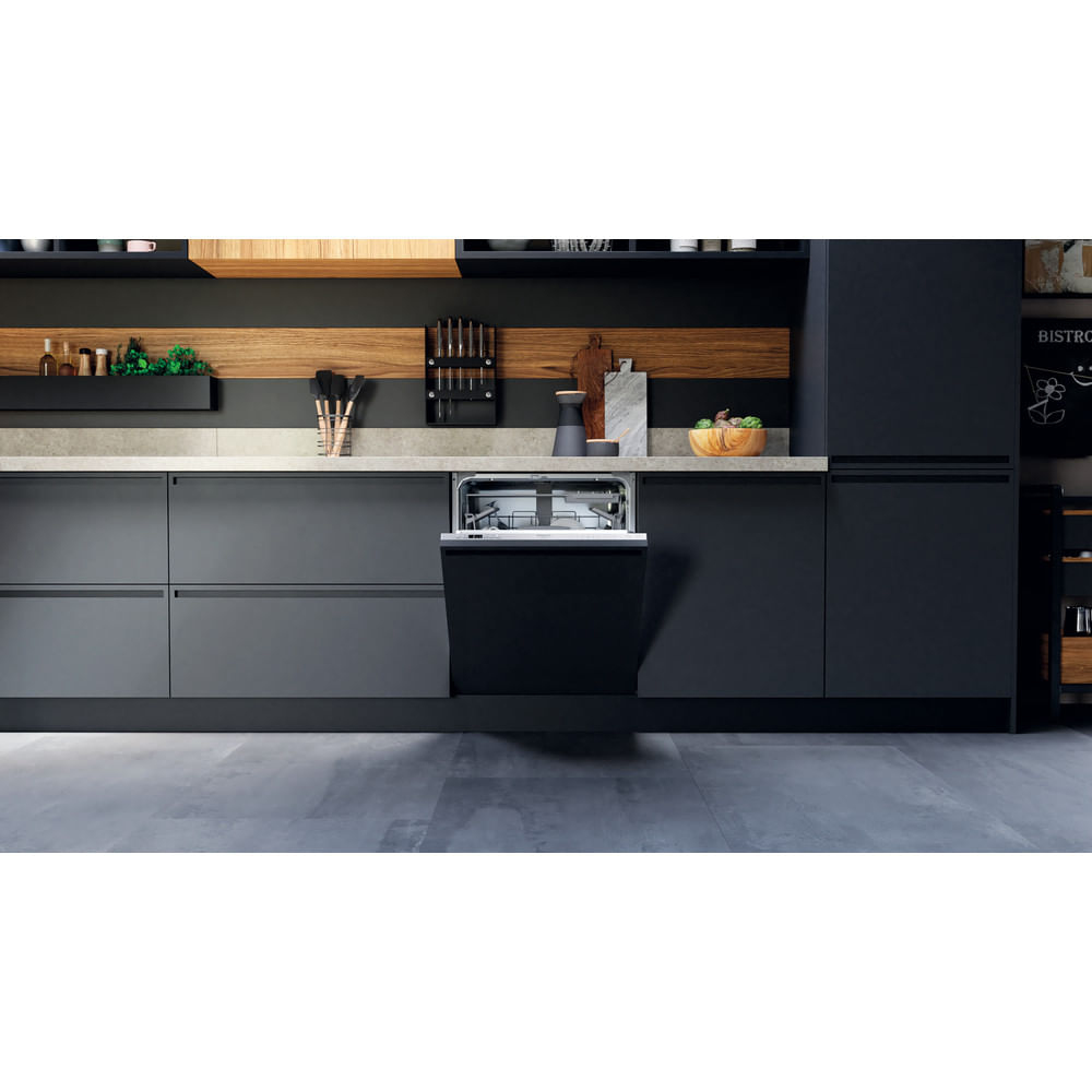 Cucina moderna con lavastoviglie nera. Armadi e pareti scuri. Piano di lavoro grigio chiaro. Elementi in legno aggiungono calore.