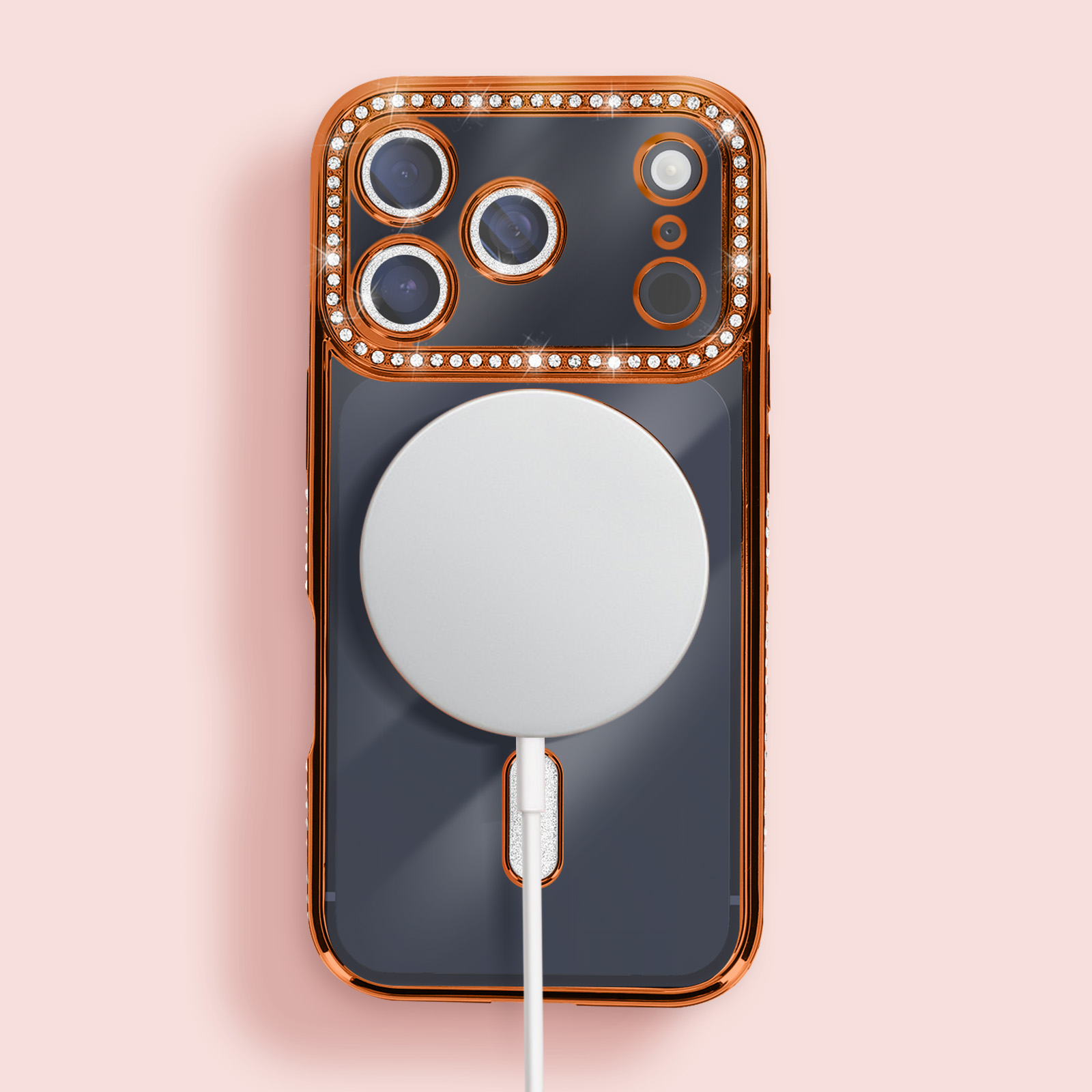Coque de téléphone avec cadre cuivré et strass, dos gris, chargeur blanc et fond rose clair.