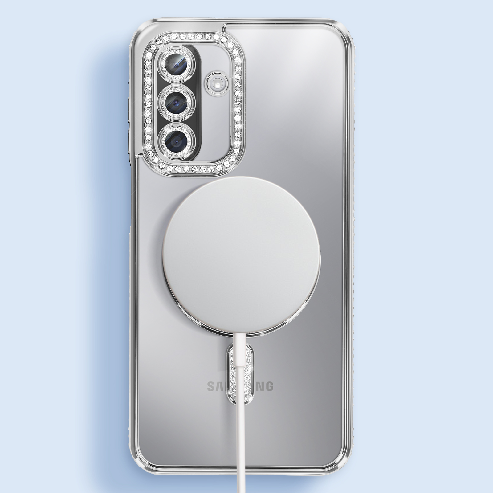 Coque de téléphone transparente avec fixation circulaire et zone caméra sertie de bijoux. Câble blanc. Fond bleu clair.