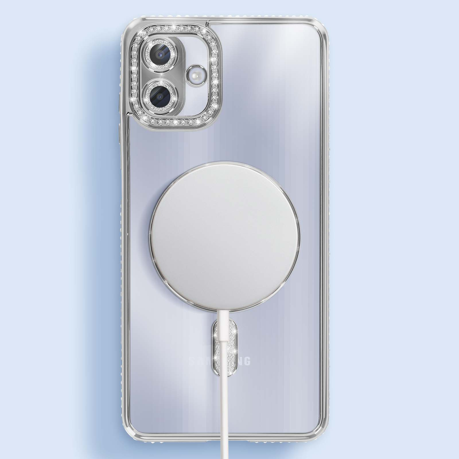 Custodia trasparente per telefono con caricabatterie MagSafe argentato. Strass intorno alla fotocamera e al caricatore. Cavo bianco collegato.
