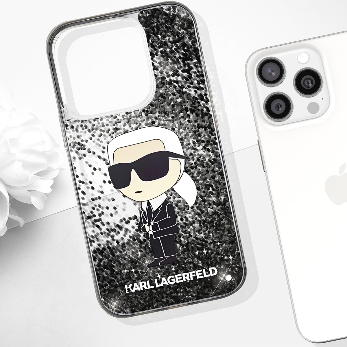Un iPhone con custodia Karl Lagerfeld. La custodia ha un cartone di Karl con occhiali da sole su sfondo glitterato. Un altro telefono accanto.