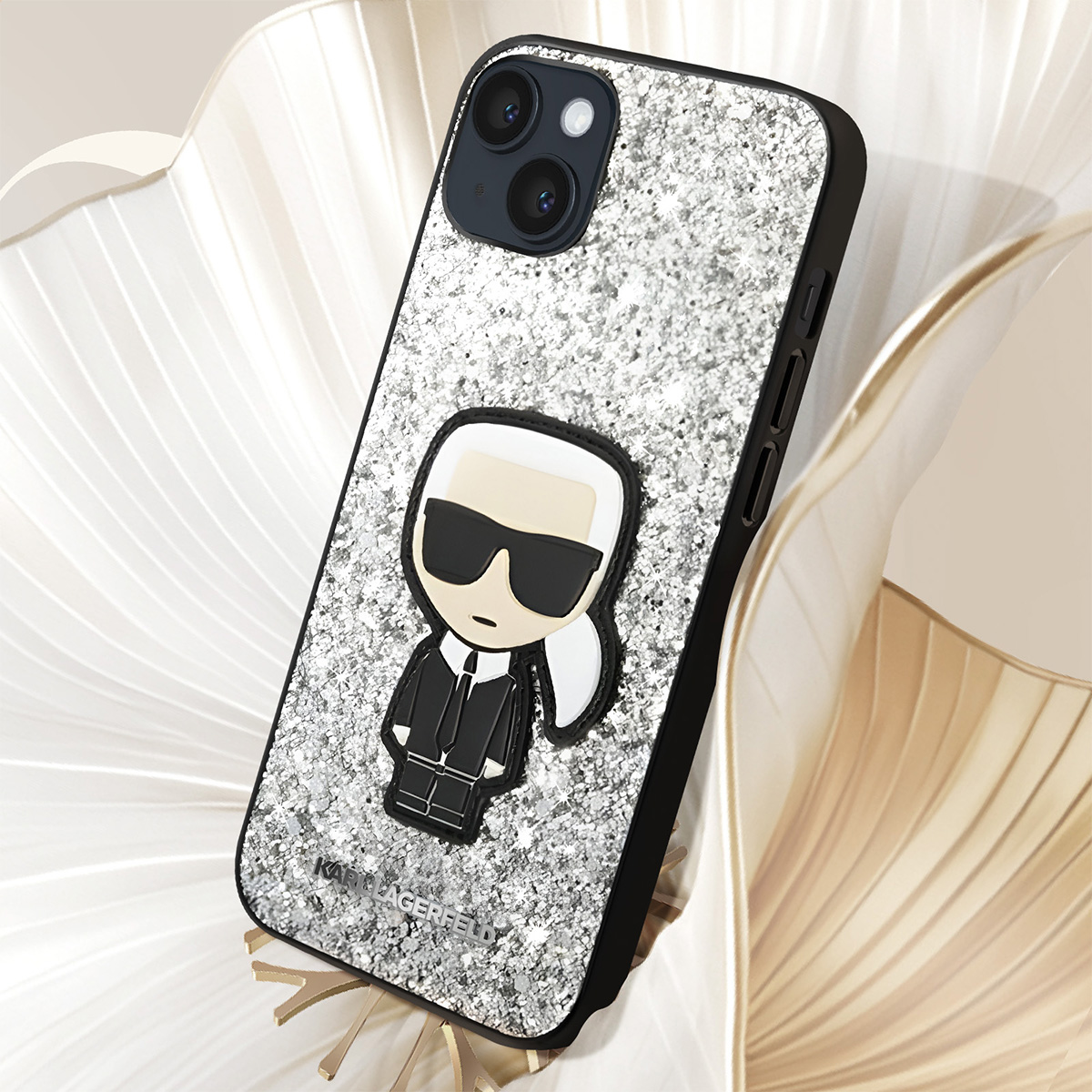 Una custodia per telefono con un design glitterato argentato e una figura di Karl Lagerfeld in bianco e nero.