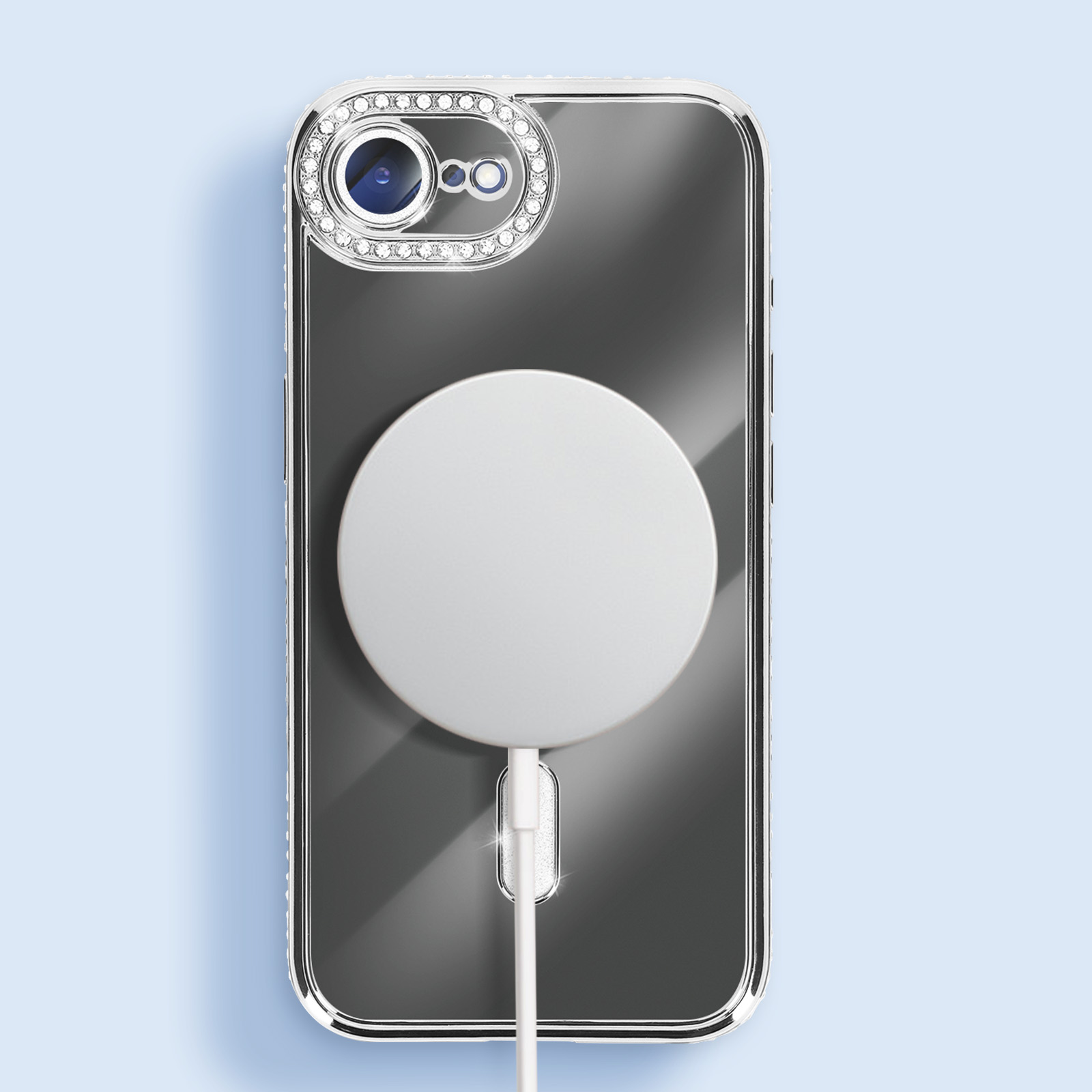 Transparante telefoonhoes met een MagSafe-oplader. De hoes heeft een met edelstenen bezette cameraring. Achtergrond lichtblauw.