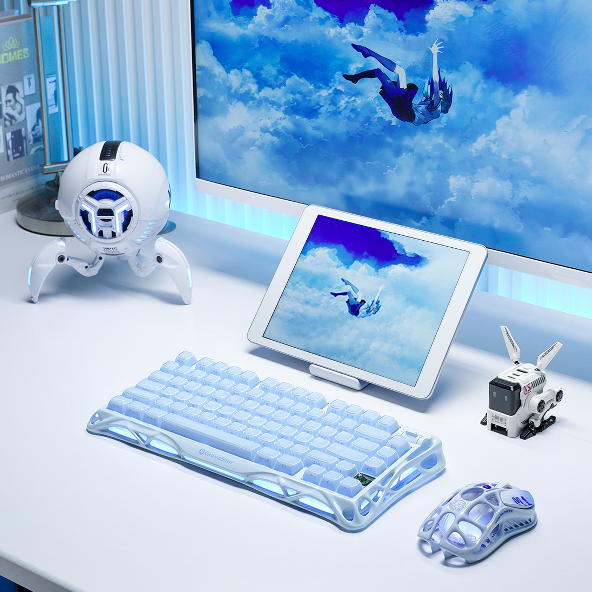 Ustawienie biurka z klawiaturą, myszą, głośnikiem, tabletem i monitorem ze zdjęciem osoby spadającej z nieba.