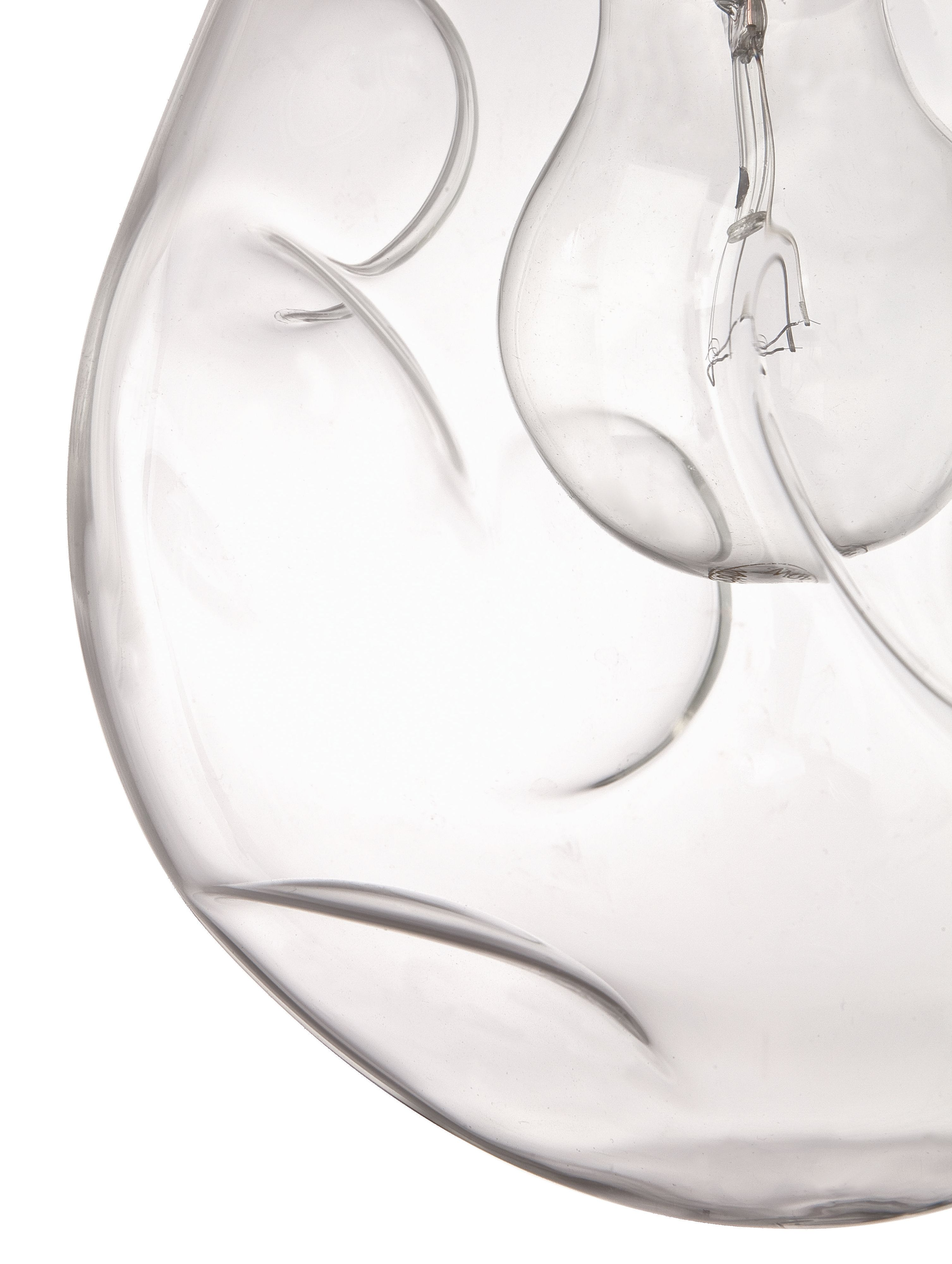 Nahaufnahme einer durchsichtigen Glaslampe mit einer Glühbirne. Das Glas hat ein abstraktes Design.