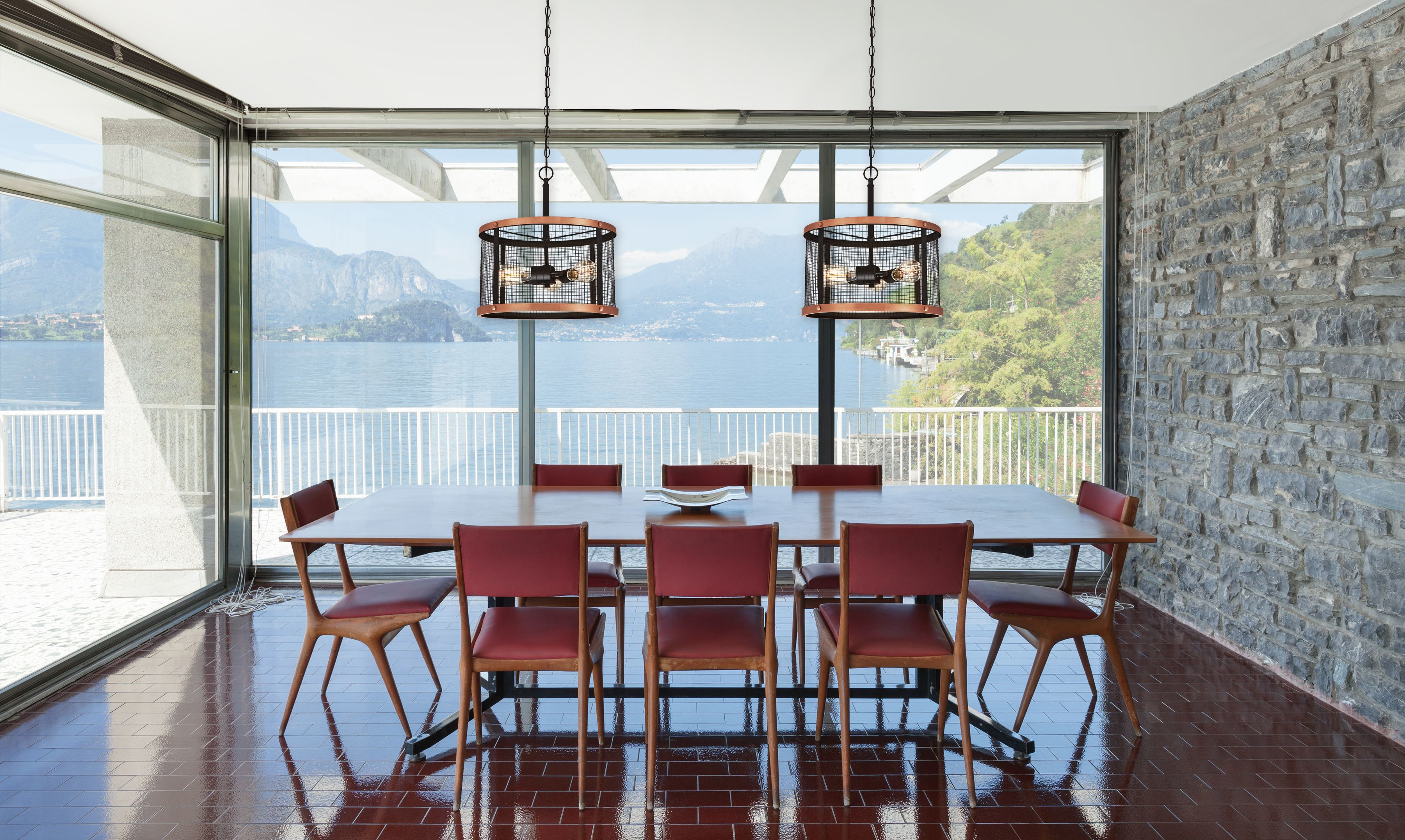 Esszimmer mit langem Tisch, roten Stühlen und großem Fenster mit Blick auf See und Berge. Zwei Hängelampen.