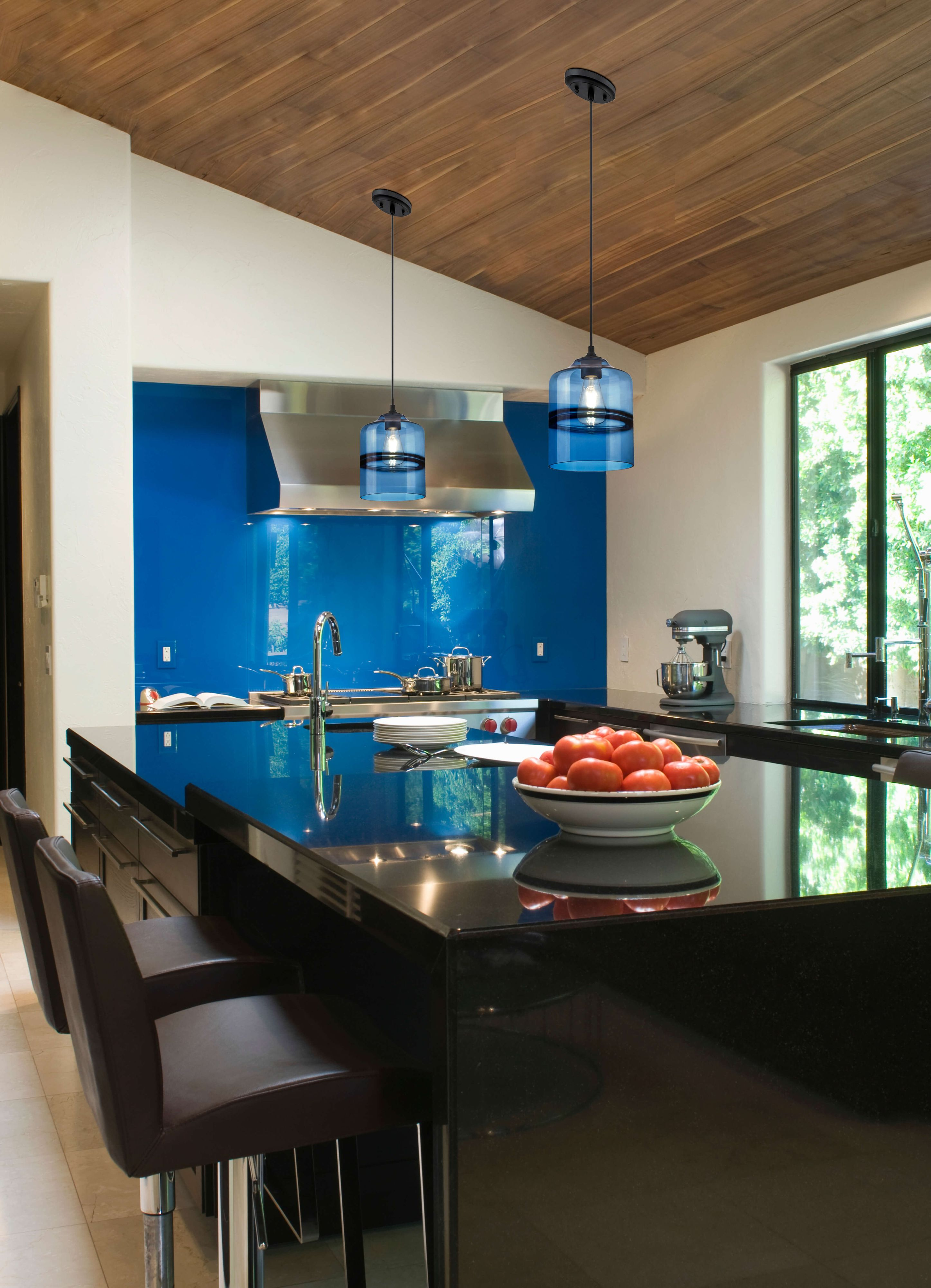 Moderne Küche mit blauem Glas-Backsplash, schwarzer Insel mit Tomaten, Pendelleuchten und Hockern.