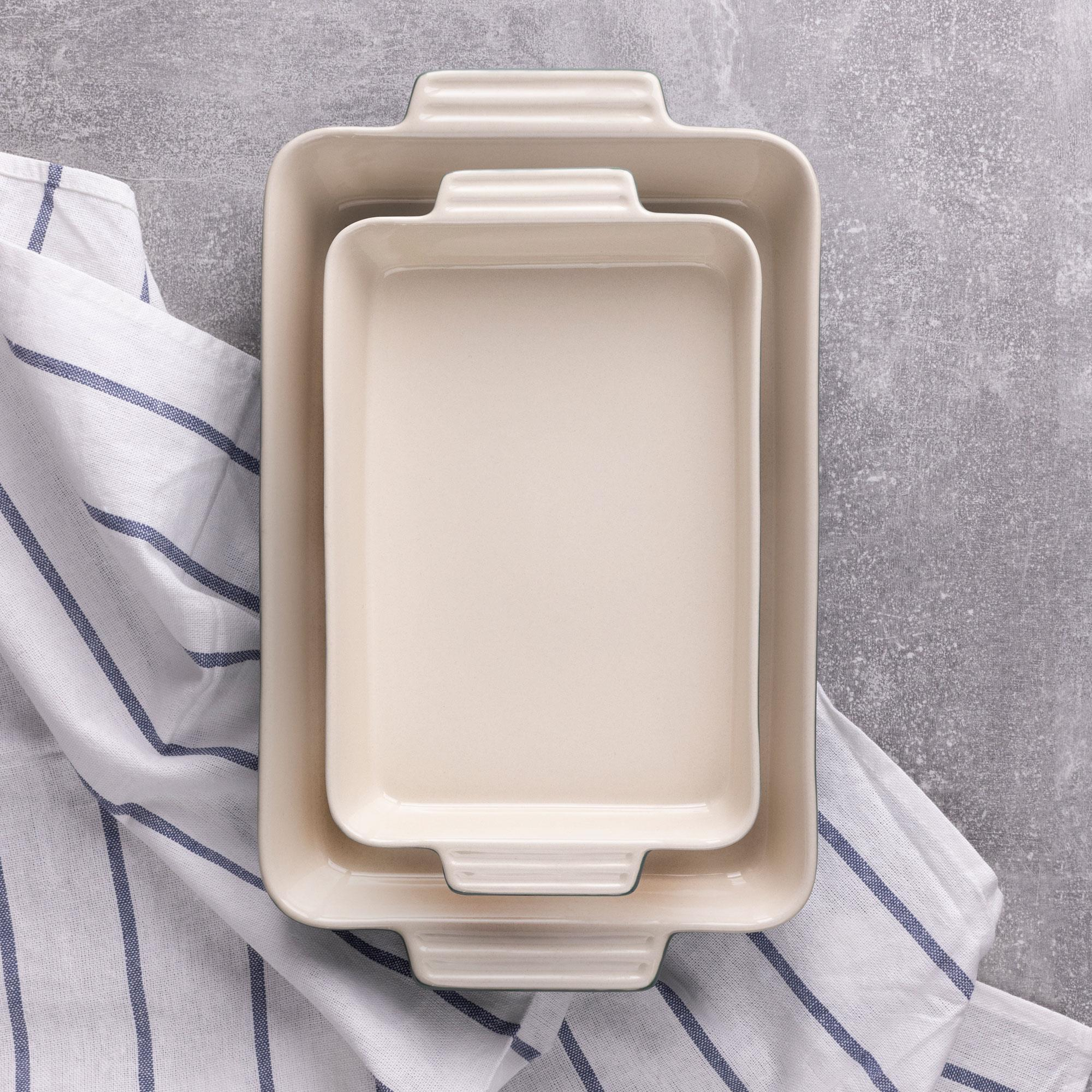 Dos fuentes rectangulares beige, una dentro de la otra, sobre una toalla a rayas azules y blancas.