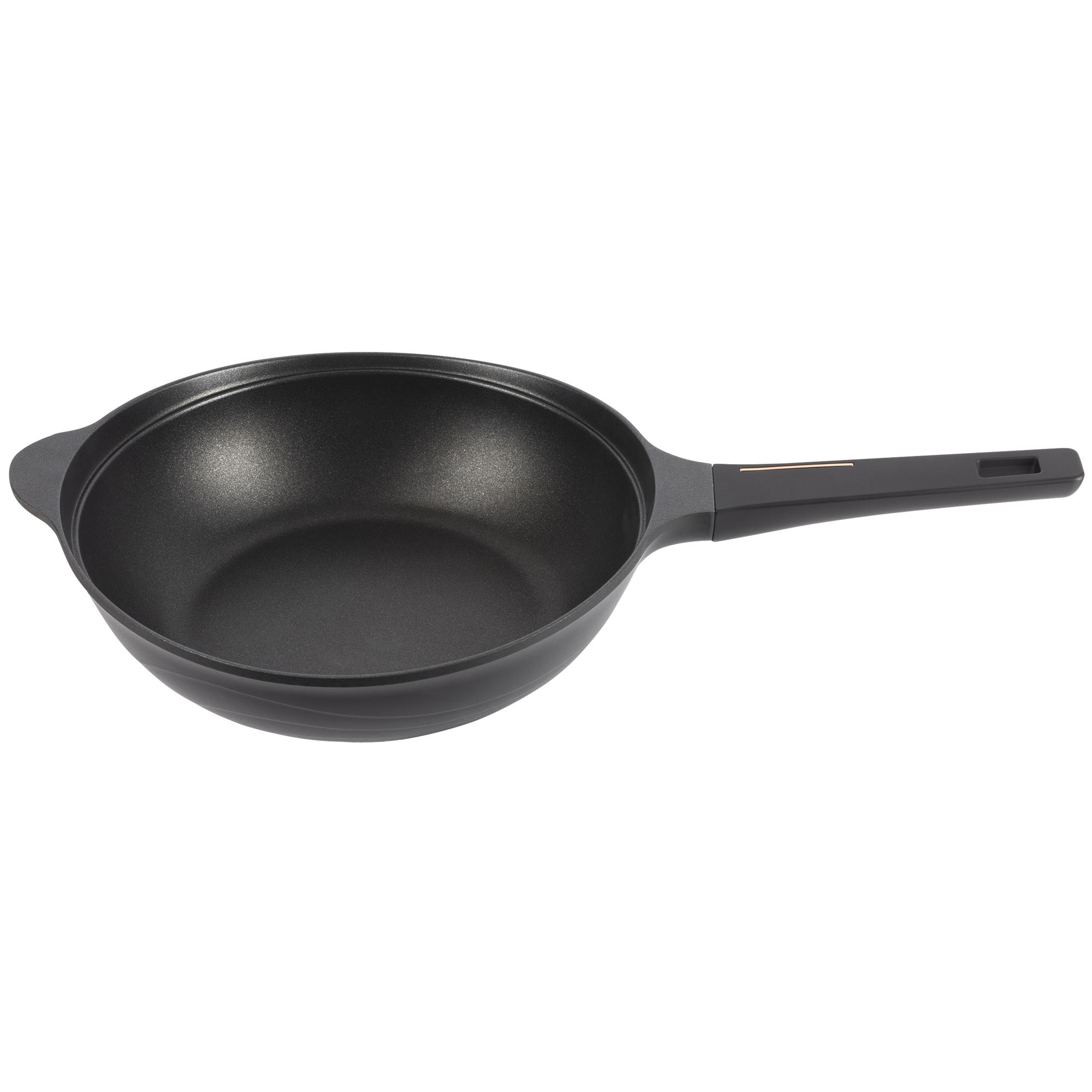 Un wok negro con mango largo y un pequeño lazo a la izquierda. El fondo es blanco.