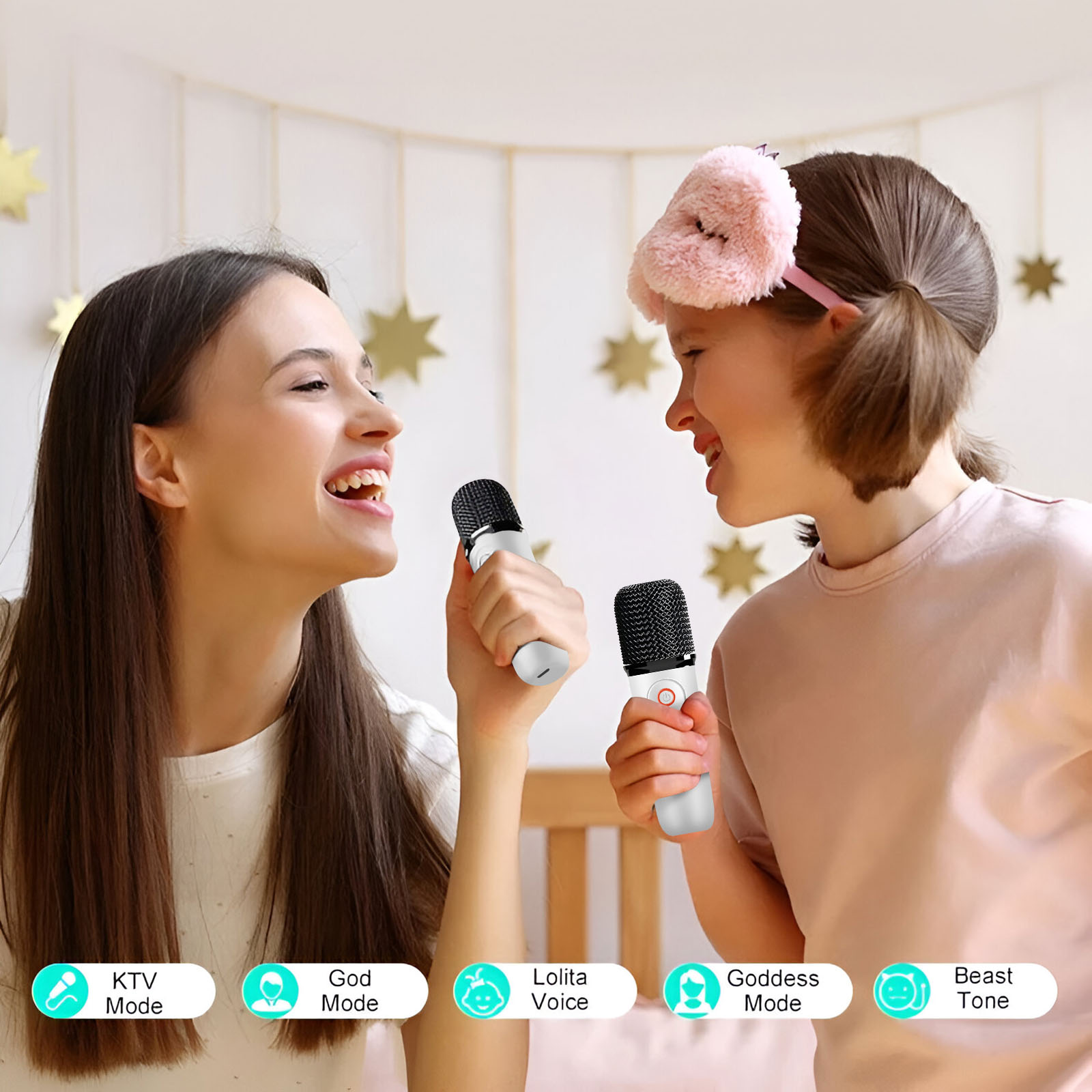 Deux femmes chantent dans des micros. L'une porte un masque de sommeil. Des décorations d'étoiles dorées sont accrochées.