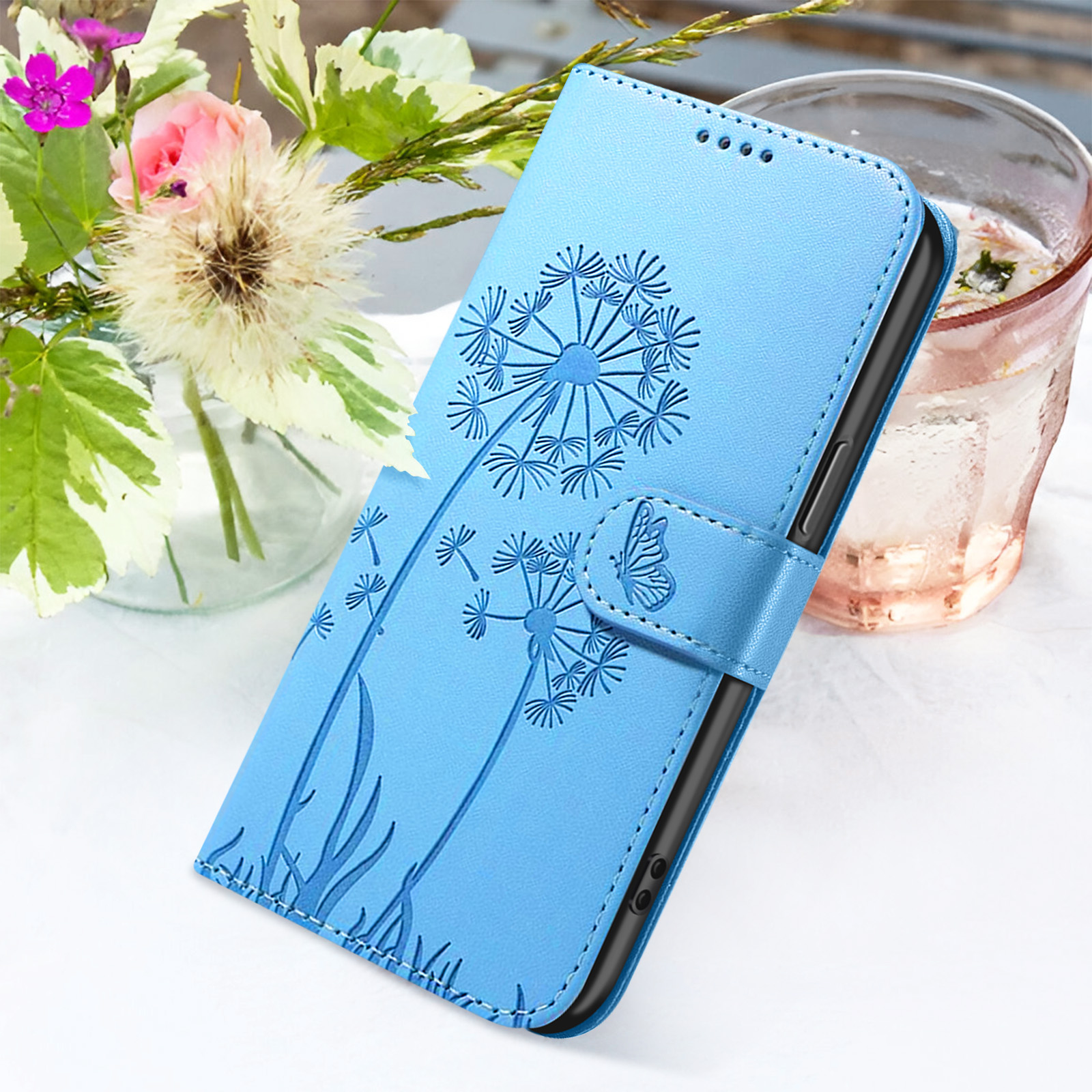 Custodia blu per telefono con design a dente di leone. Fiori e bicchiere d'acqua sullo sfondo.