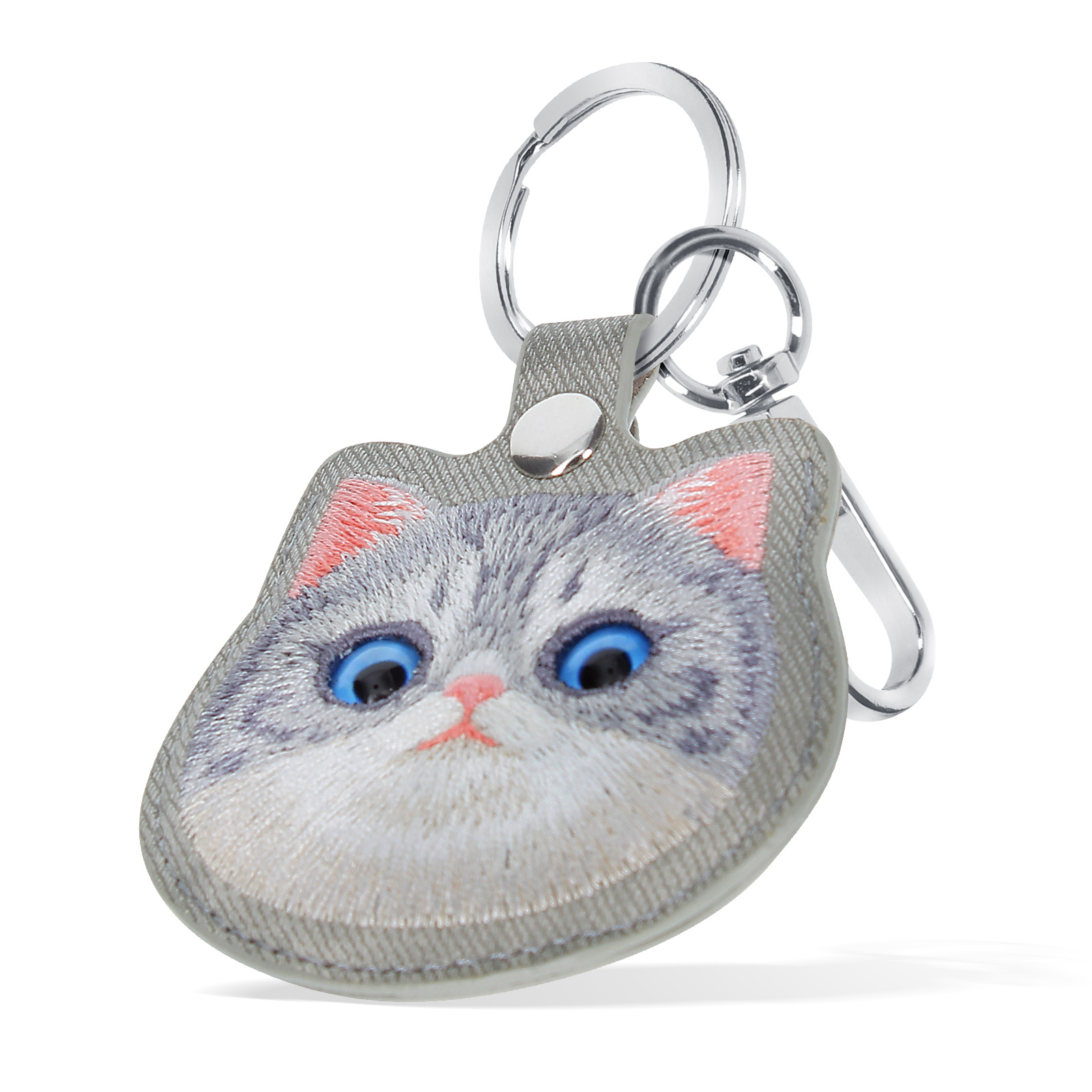 Portachiavi con faccia di gatto. Il gatto ha occhi blu, naso e orecchie rosa e pelo grigio. Il portachiavi è argentato.