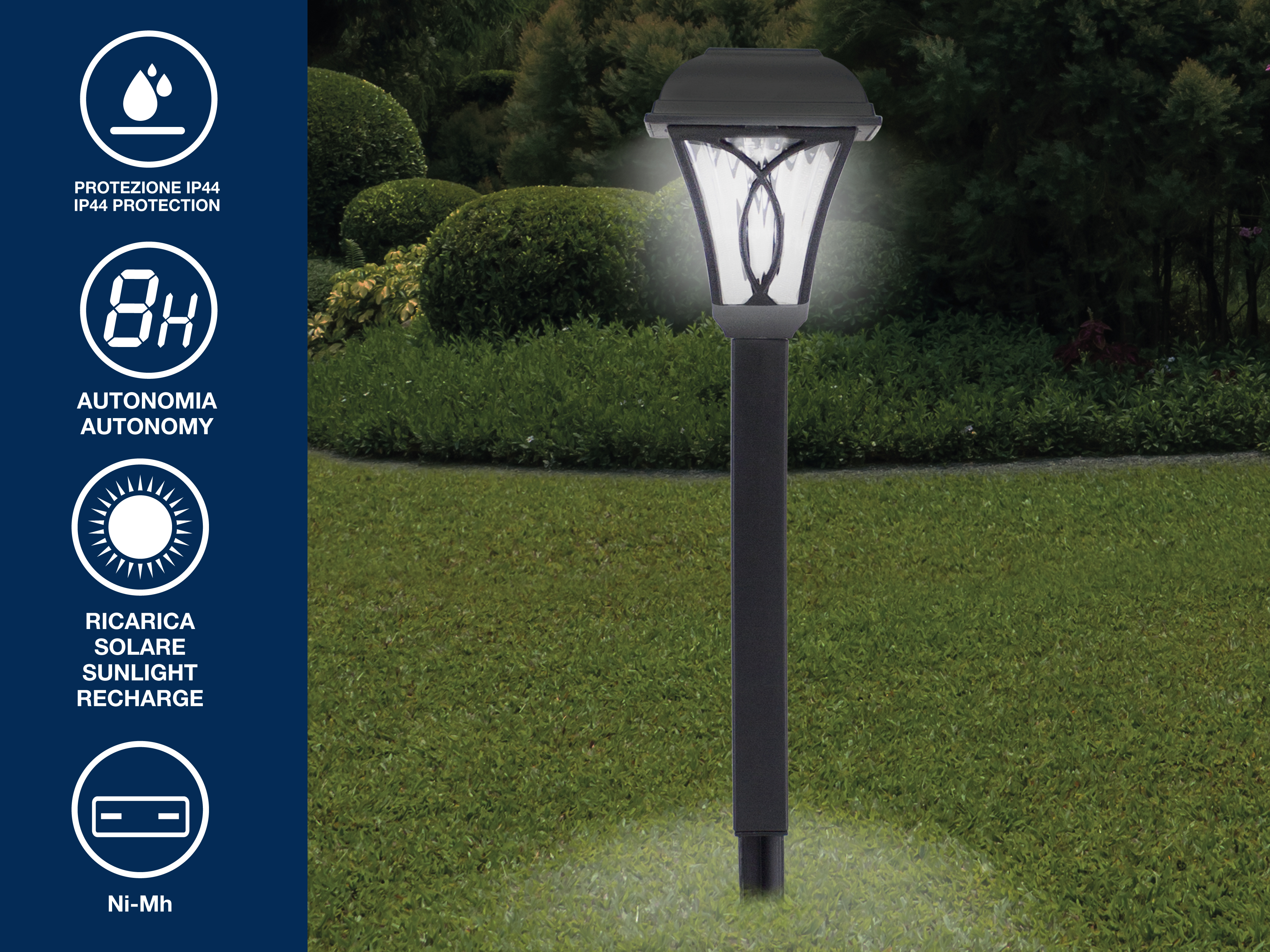Una lampada solare con palo scuro è in un giardino. Lo sfondo presenta cespugli verdi ed erba.