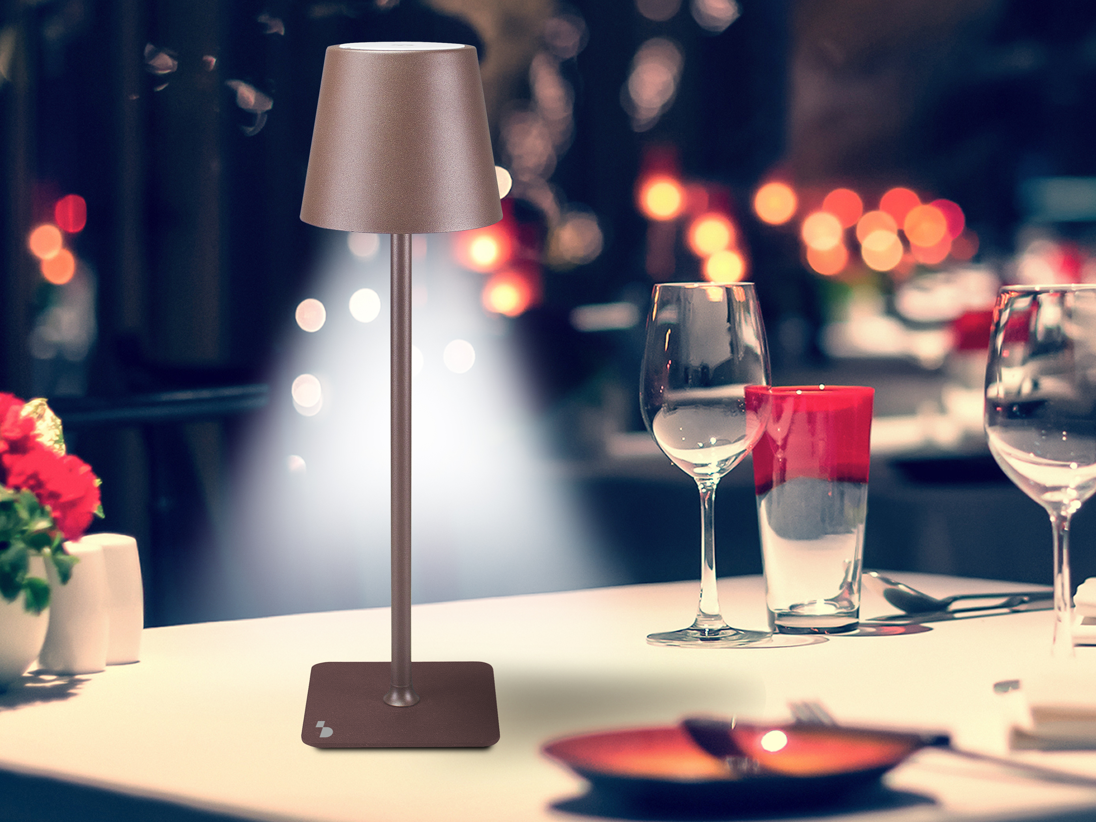 Tavolo con lampada, bicchieri, bicchiere rosso e sfondo sfocato con luci.