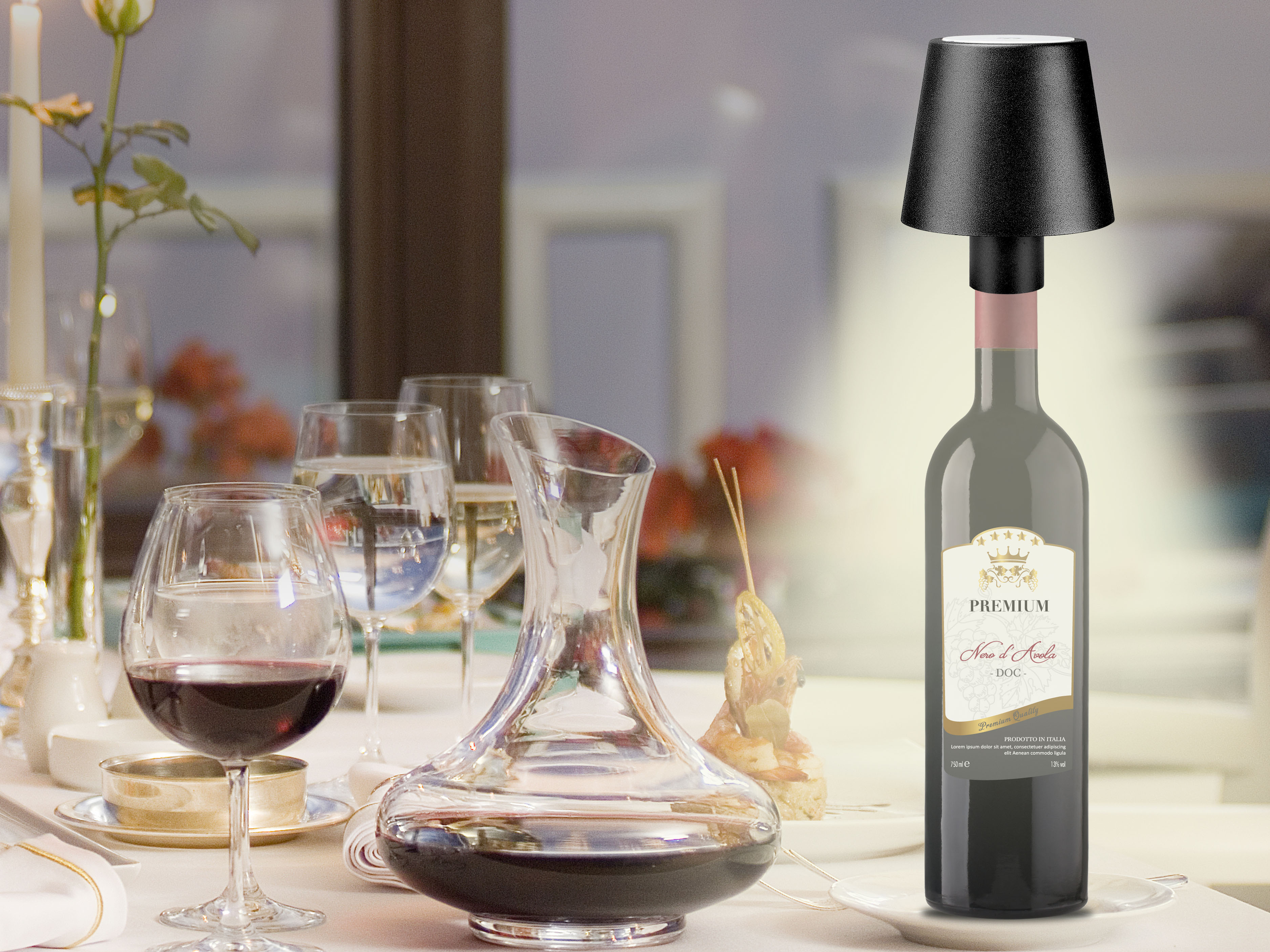 Una scena di cena con calici, una caraffa e una bottiglia di vino con una lampada sopra. C'è anche del cibo.
