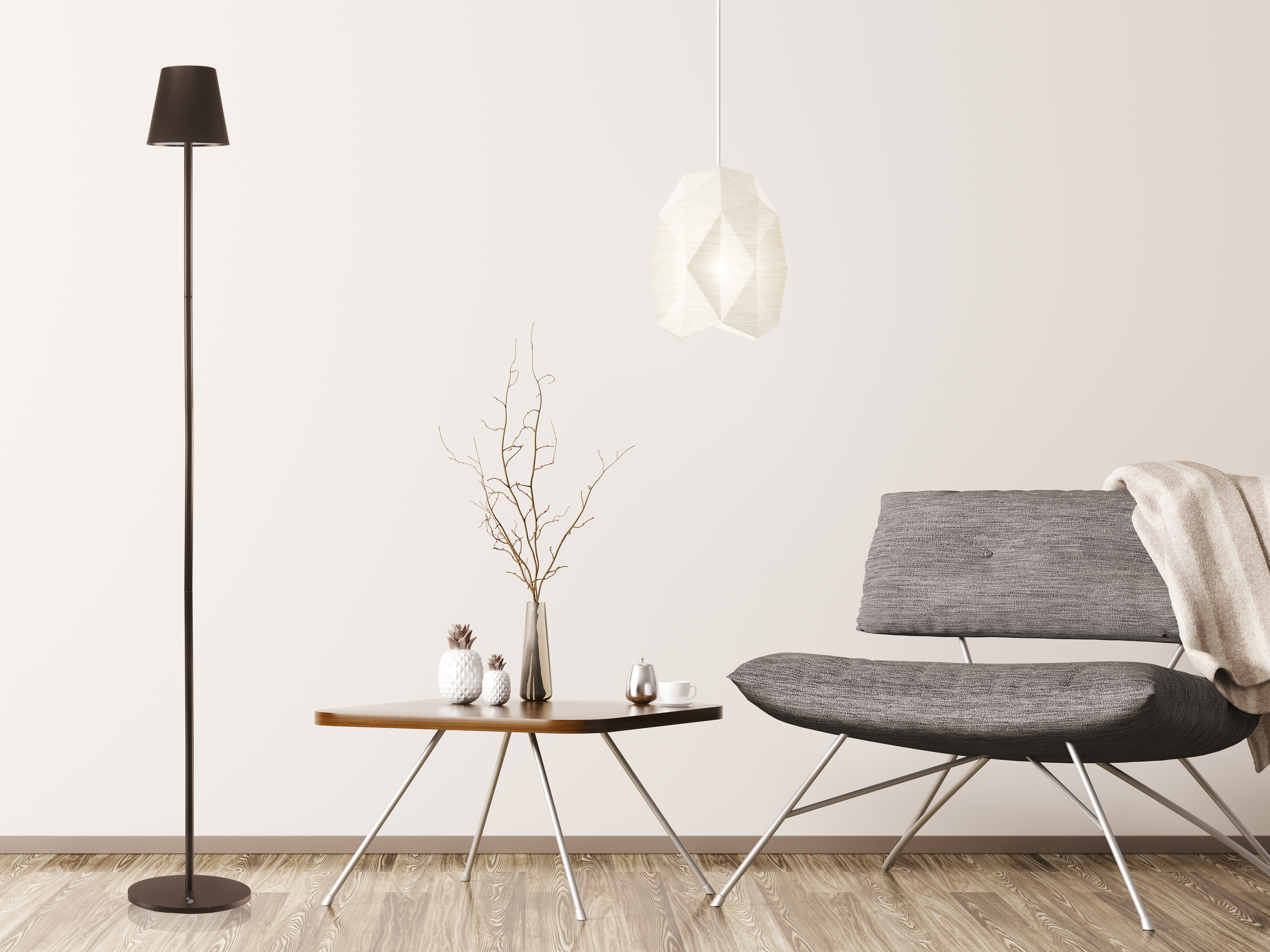 Scena di soggiorno con sedia grigia, tavolo, lampada e decorazioni. Lo sfondo è un muro bianco e pavimento in legno.