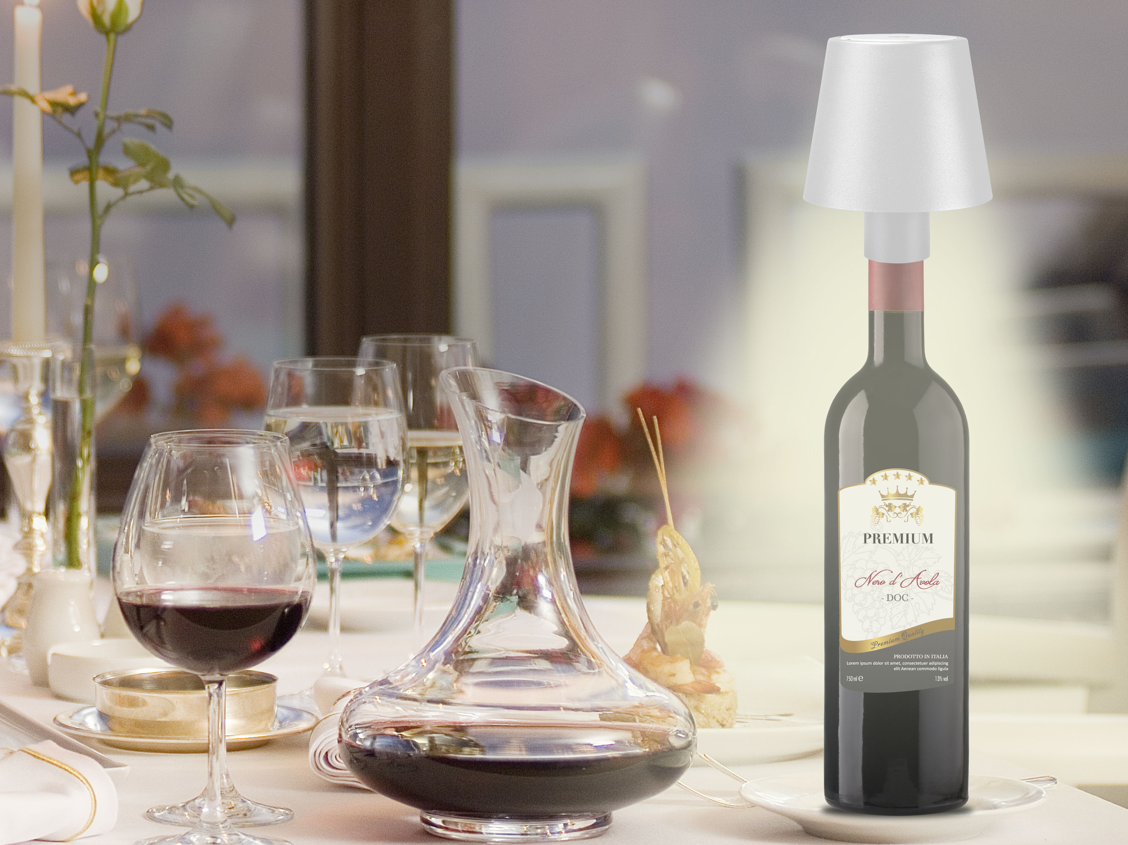 Tavolo con calici, caraffa, bottiglia di vino con lampada e fiore.
