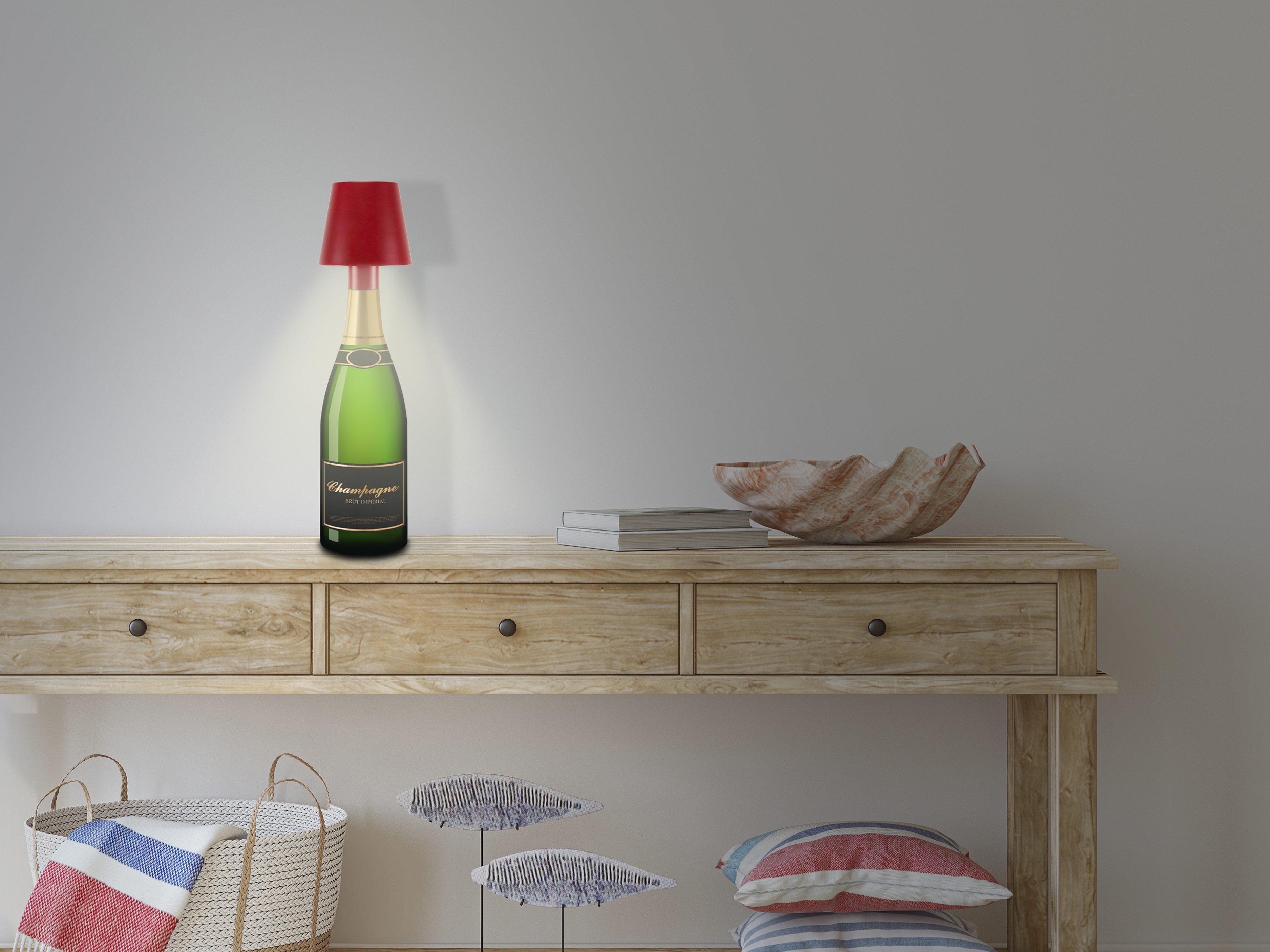 Una lampada a bottiglia di champagne è su un tavolo di legno. Accanto un guscio e libri. Cesto e cuscini sotto.