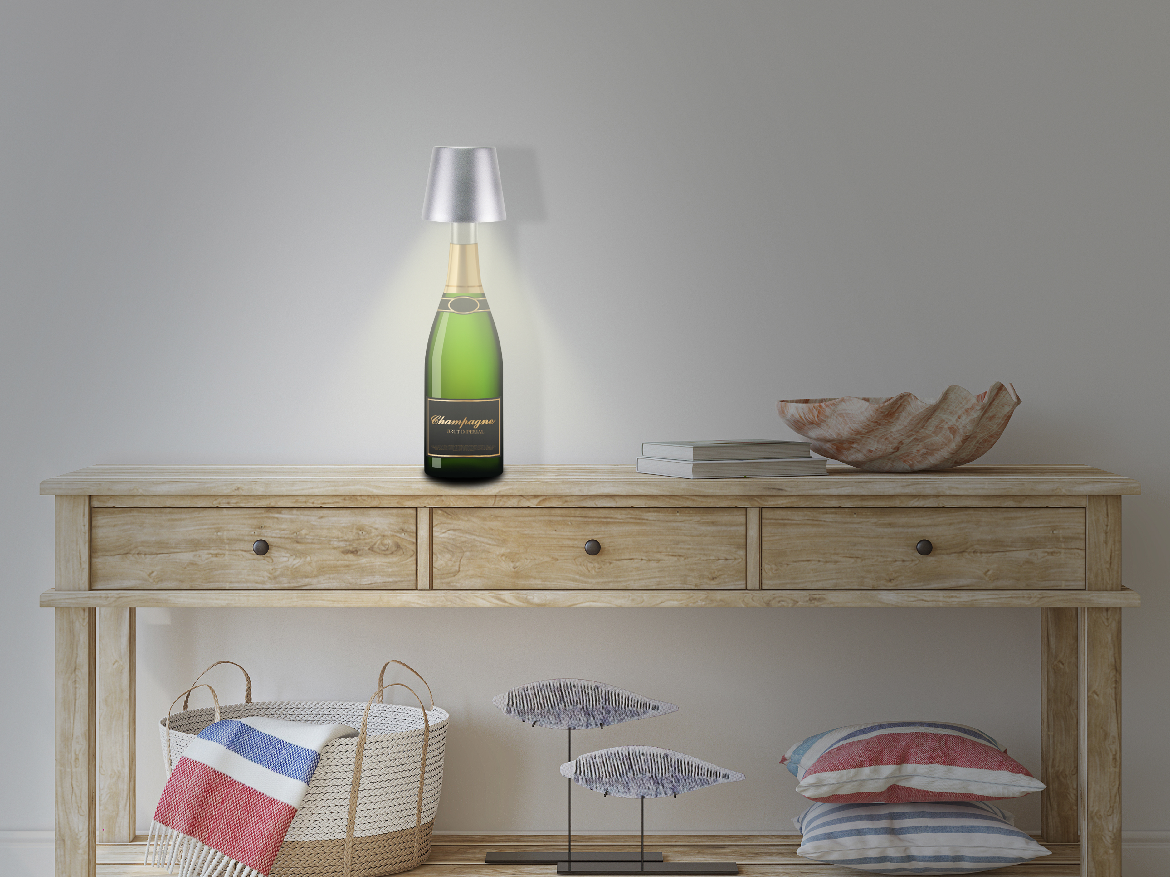 Una lampada a forma di bottiglia di champagne è su un tavolo di legno. Sul tavolo ci sono anche una conchiglia, libri e decorazioni.