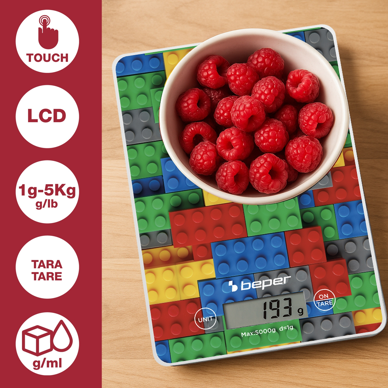 Una bilancia da cucina con lamponi in una ciotola. La bilancia mostra '193 g'. Ha un design colorato simile ai Lego.