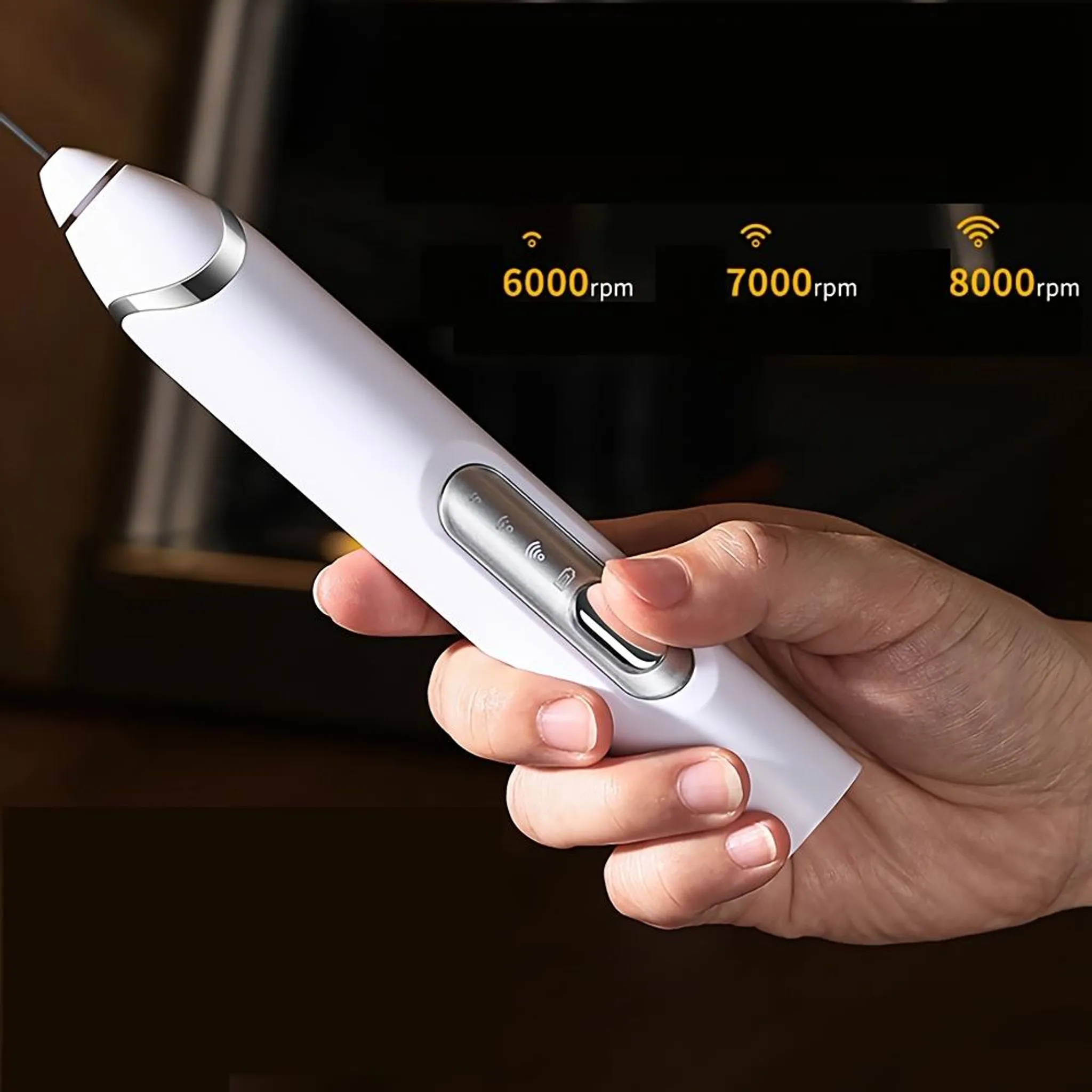 Eine Hand hält ein weißes Gerät mit silbernen Akzenten. Das Display zeigt Geschwindigkeitsoptionen: 6000, 7000 und 8000 U/min.