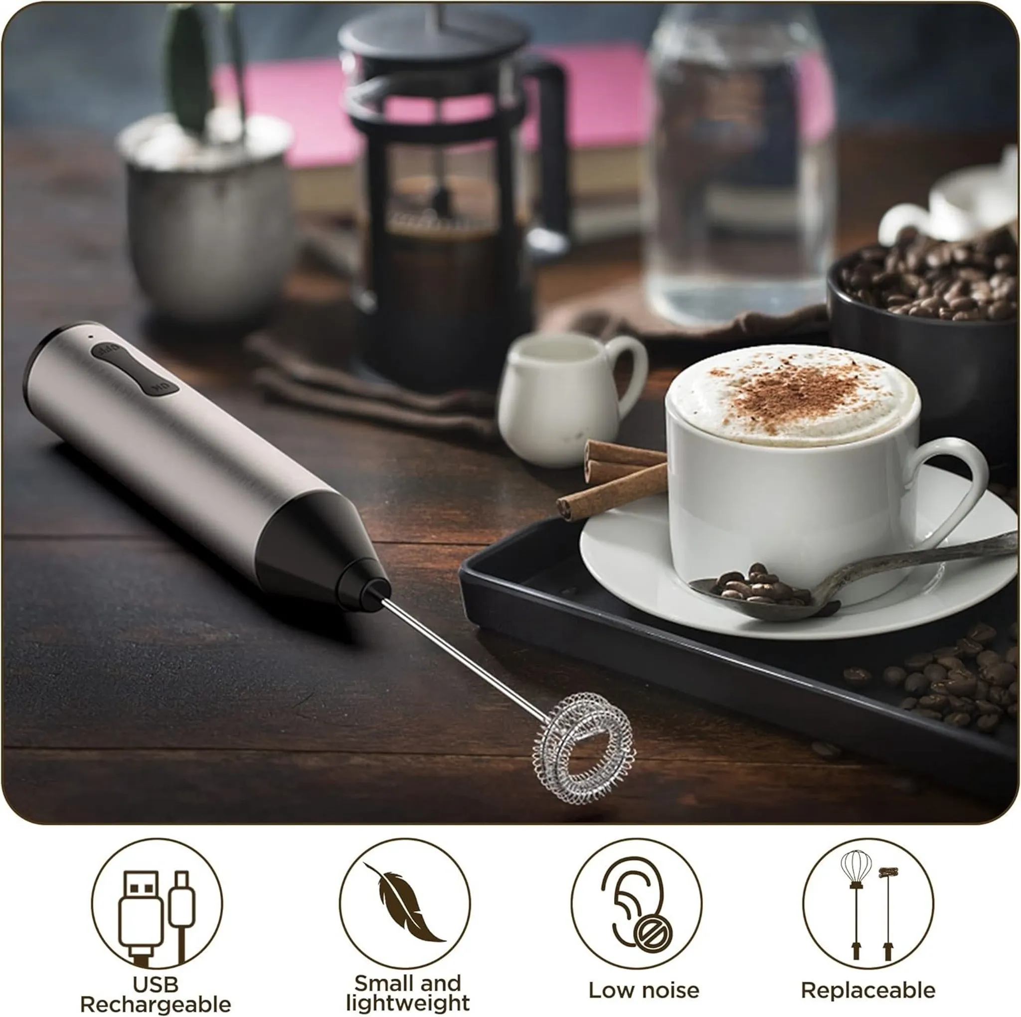 Ein Milchaufschäumer und eine Kaffeetasse mit Schaum und Zimt. Außerdem eine French Press, Kaffeebohnen und ein kleiner Krug.