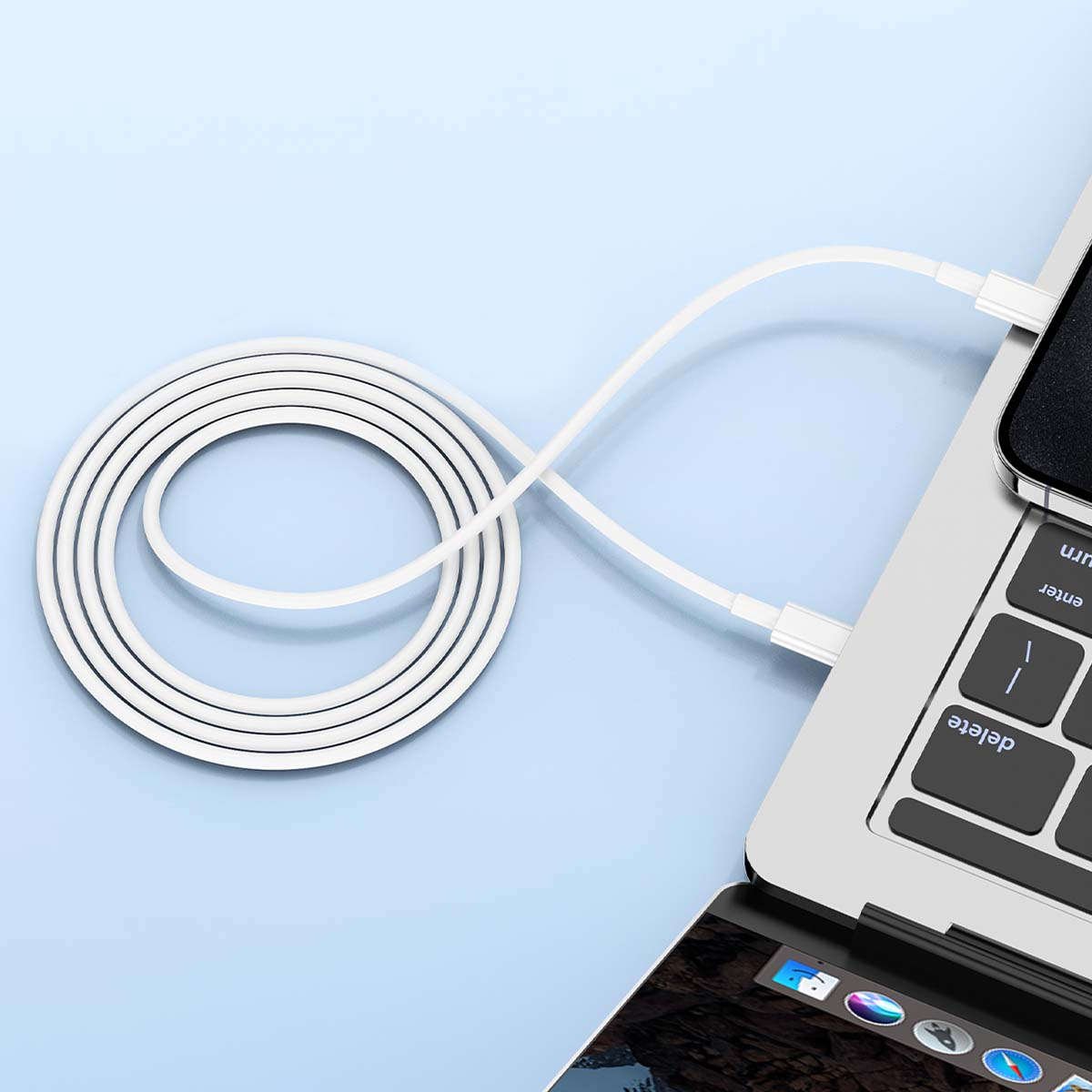 Un câble de chargement blanc est connecté à un ordinateur portable. Le câble forme une forme circulaire. Le fond est bleu clair.