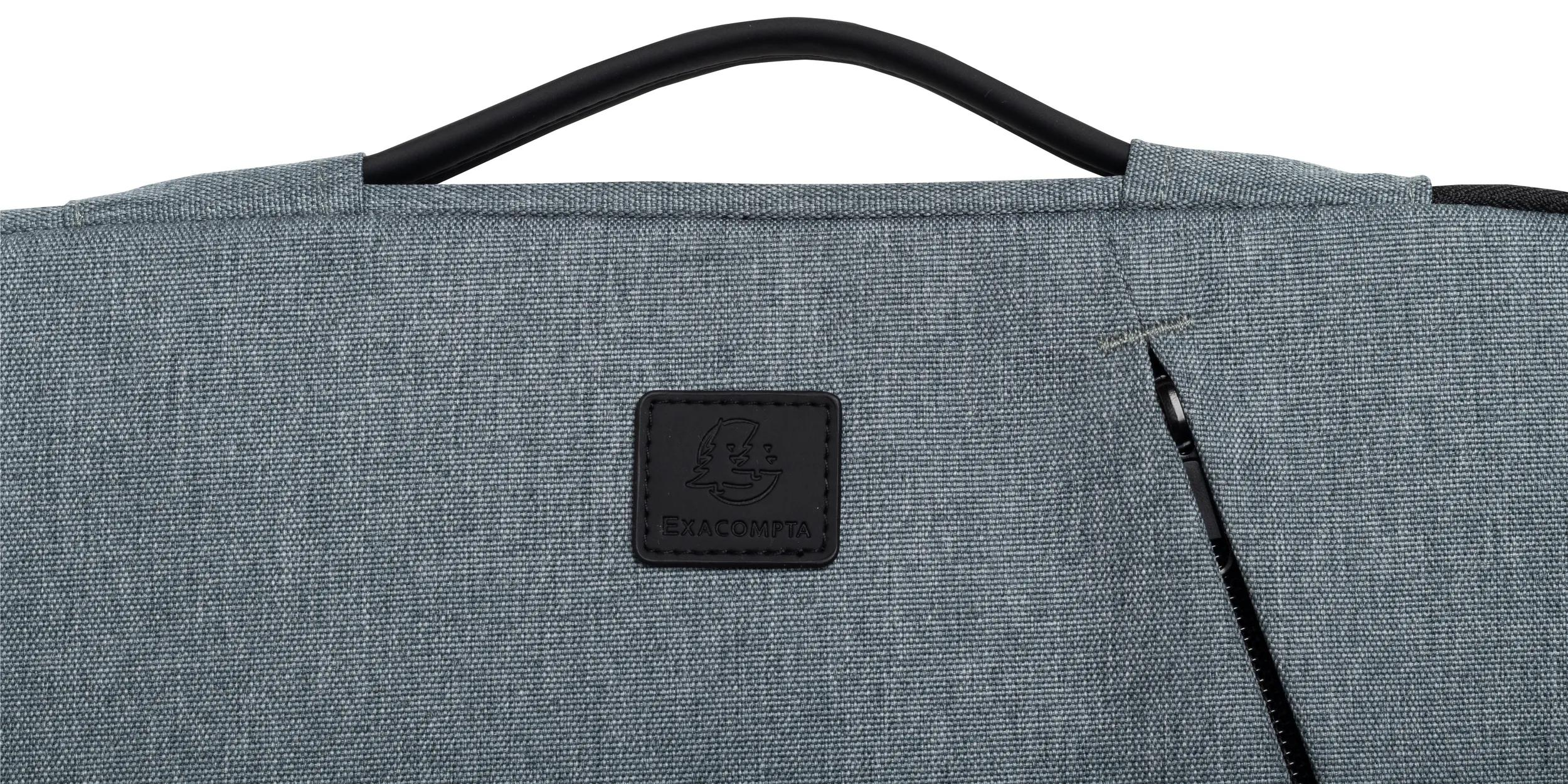 Primo piano di un tessuto blu-grigio con manico nero. Una toppa in pelle nera mostra il marchio 'EXACOMPTA'.